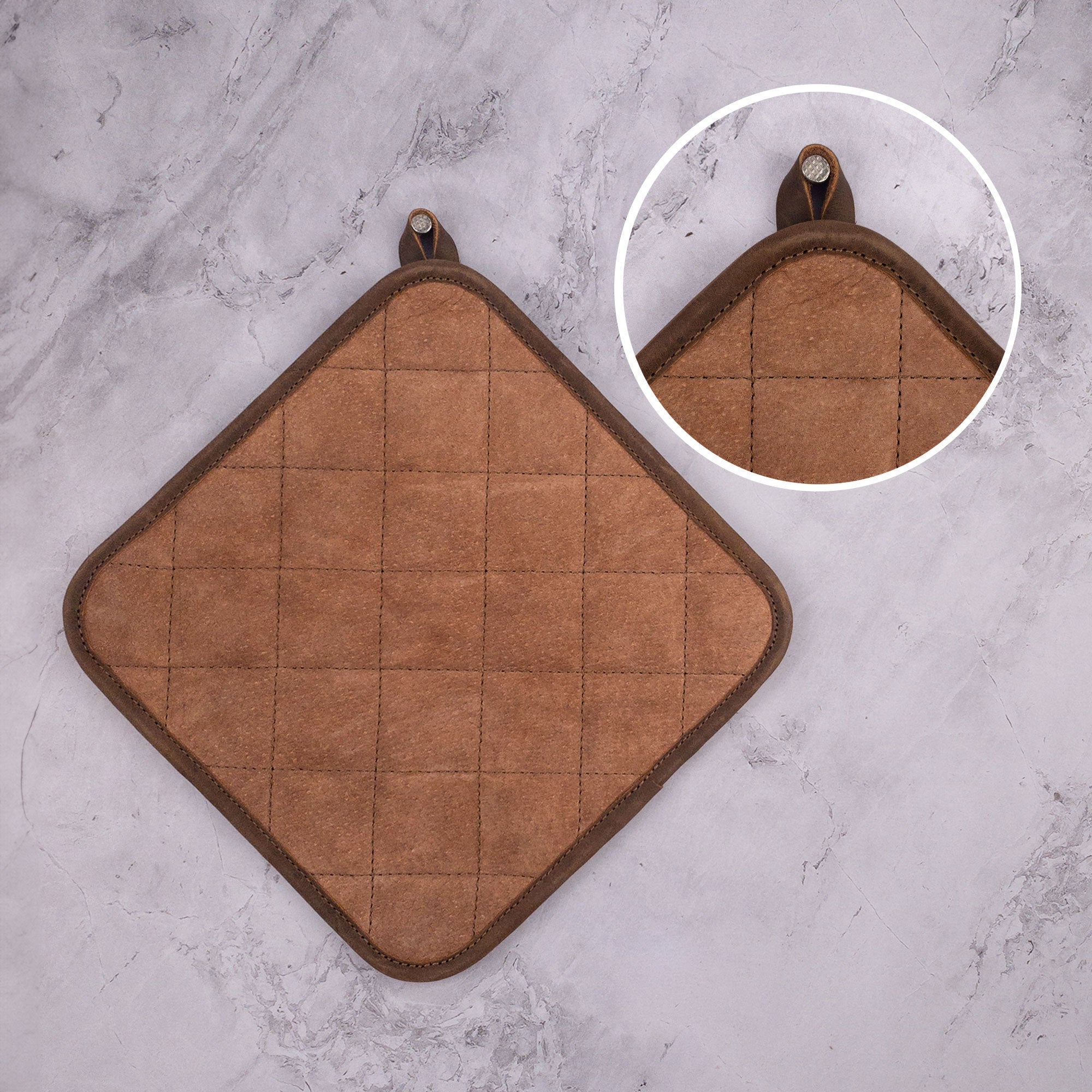 Close-up of the Cast Leather Co. Squared Hot Pot Pad, designed for optimal heat protection. This Squared Oven Mitt Heat Resistant, Hot Pot Pad (Potholder) serves as essential bakery supplies, crafted from full grain leather and sheepskin. Emphasizing small batch production, it's hand cut, hand sewn, and fire branded by skilled artisans in La Antigua Guatemala & Oaxaca Mexico.