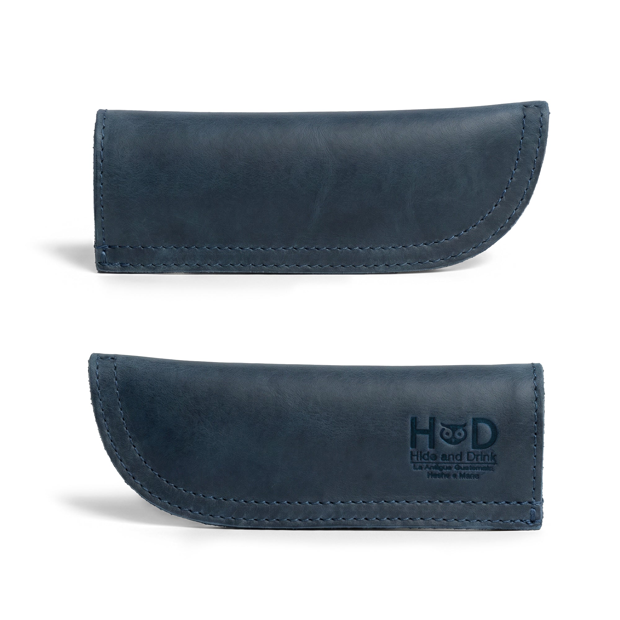 Hide & Drink Cast Iron Panhandle Cover displayed next to its packaging. This artisan hot handle protector combines functionality with style, made from double stitched full grain leather. Handmade in La Antigua Guatemala & Oaxaca Mexico, it's perfect for adding flair to any kitchen.