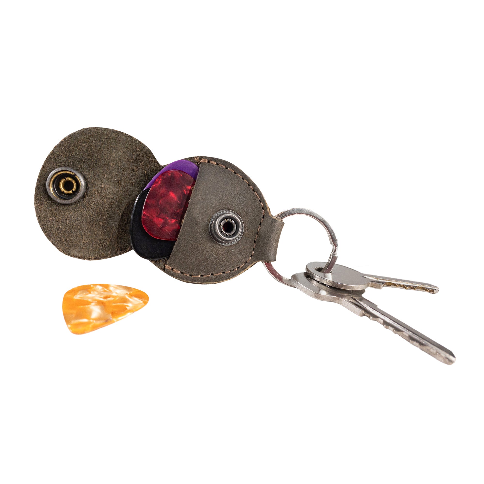Close-up of the Key Chain & Guitar Pick Holder by Hide & Drink, showcasing a secure snap and vibrant guitar picks. This Guitar Pick Holder with Ring acts as a key organizer for guitar players and boasts high-quality Full Grain Leather. It's a testament to small batch production with Hand Cut and Hand Sewn craftsmanship, featuring a fire branded design, made in La Antigua Guatemala & Oaxaca Mexico.