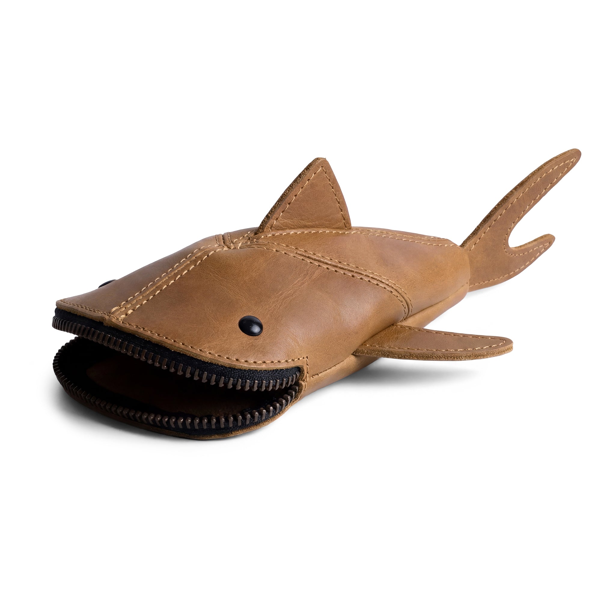 Showcasing the Hide & Drink Leather Shark Pouch, this stylish zippered pouch stands upright and showcases its shark design. Ideal as a makeup bag or wallet, this small batch production piece is crafted from full grain leather, featuring hand cut and hand sewn details. It's a unique artisan accessory handmade in La Antigua Guatemala & Oaxaca Mexico.