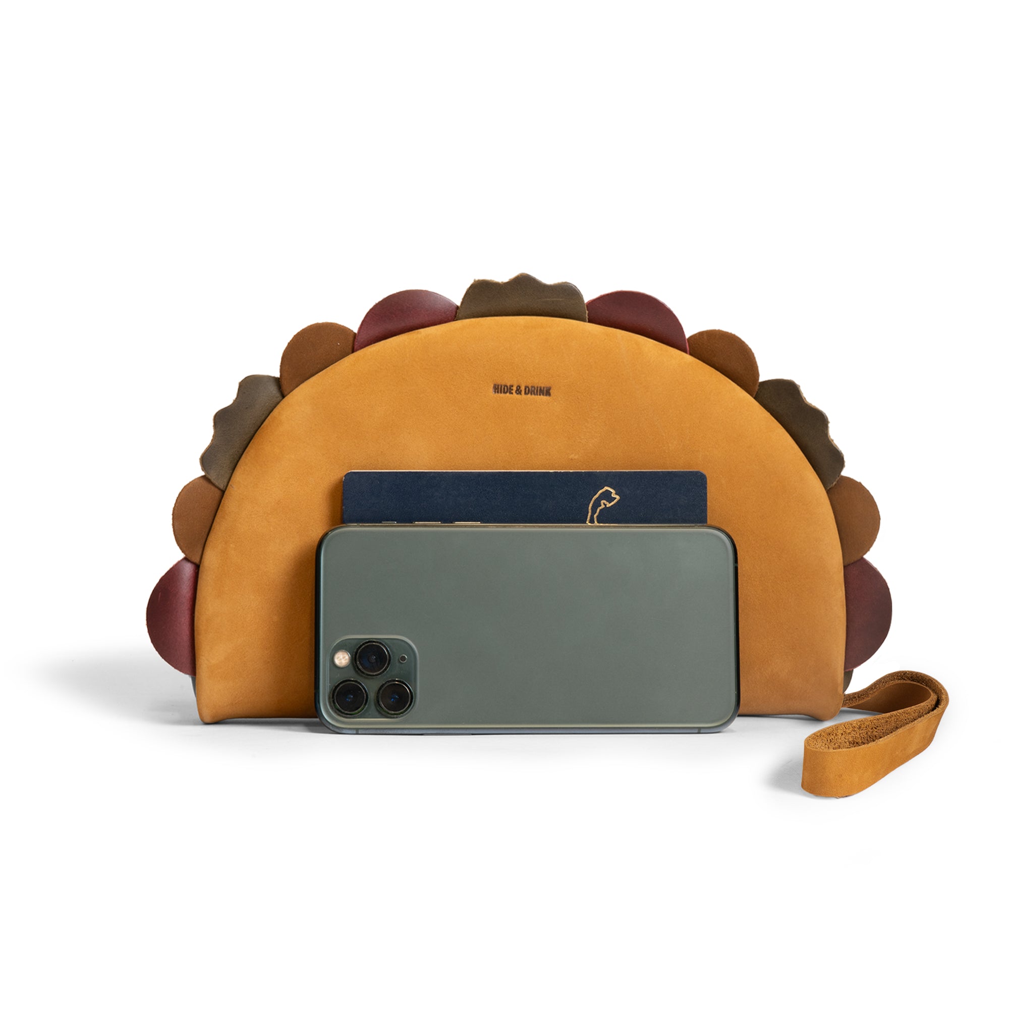 Hide & Drink Taco Clutch Bag shown holding a smartphone and passport, highlighting its compact storage; Taco Clutch Bag Full Grain Leather by StockyardX, made through Small Batch Production with Hand Cut, Hand Sewn, Fire Branded Artisan craftsmanship, Handmade in La Antigua Guatemala & Oaxaca Mexico.