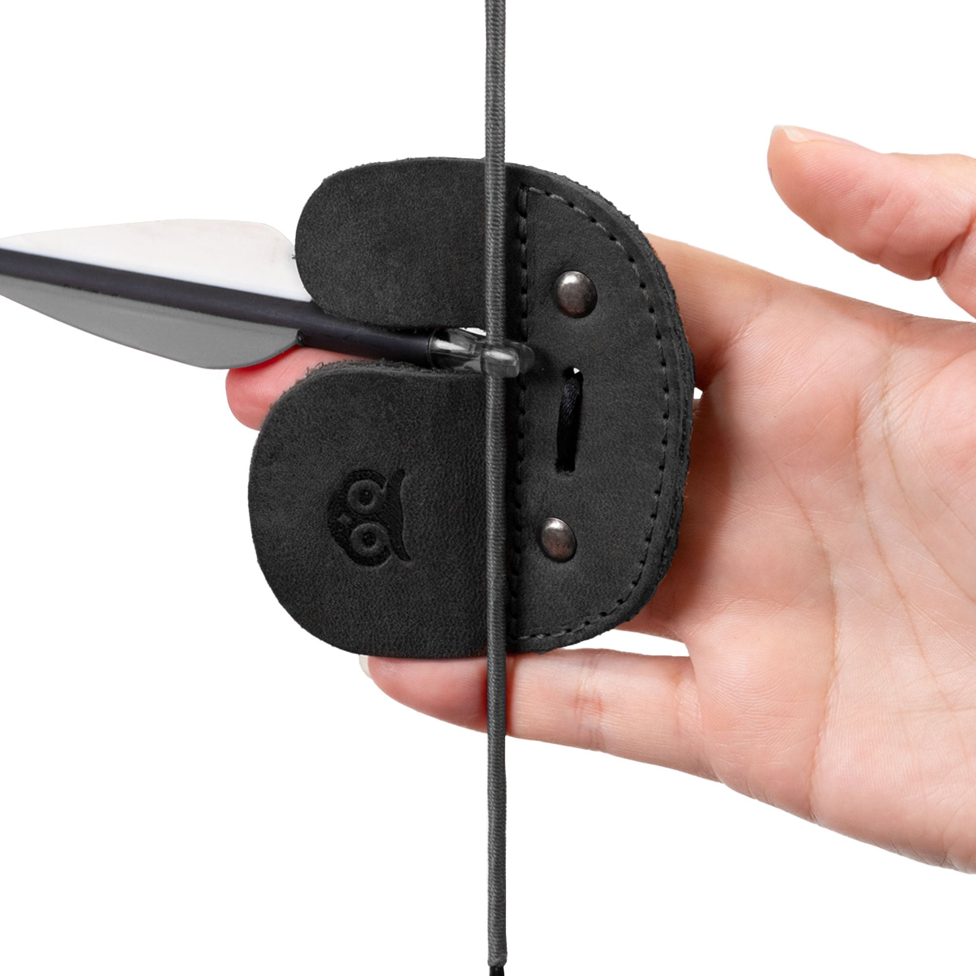 Demonstration of the Right Handed Archery Finger Protector by Hide & Drink, illustrating its use during shooting practice. This Archery Finger Tab, made from high-quality Full Grain Leather, serves as a reliable Protect Guard for recurve bows. Each piece upholds the values of Small Batch Production, showcasing Hand Cut, Hand Sewn craftsmanship, and fire branding, created in La Antigua Guatemala & Oaxaca Mexico.