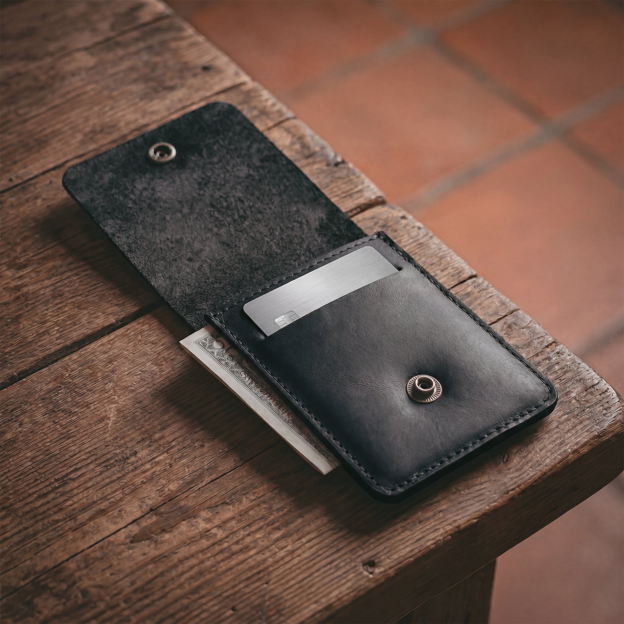 Interior view of a black Vertical Wallet by Hide & Drink, showing its card holder and cash storage. This Vertical Front Pocket Wallet with Card Slot is crafted for compact storage solutions, made from full grain leather showcasing small batch production with hand cut and hand sewn details, fire branded just for you. Handmade in La Antigua Guatemala & Oaxaca Mexico.