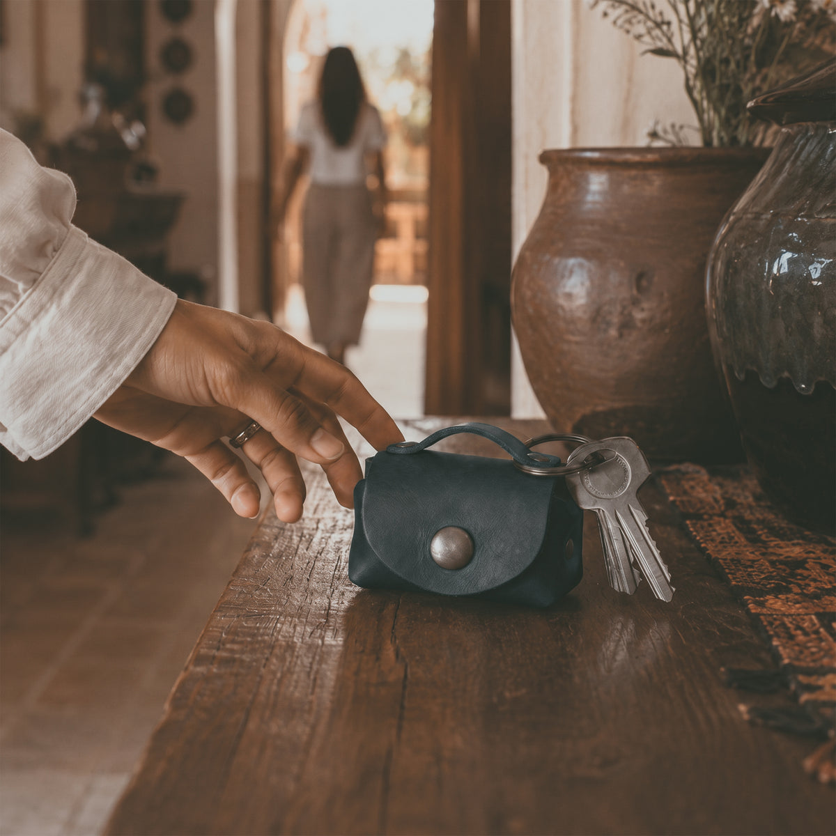 Inside view of the Tiny Handbag Keychain by Hide & Drink, filled with coins to illustrate its usability. This keychain, made from Full Grain Leather, is a great example of handmade craftsmanship from StockyardX, highlighting the artisan skills from Oaxaca Mexico.