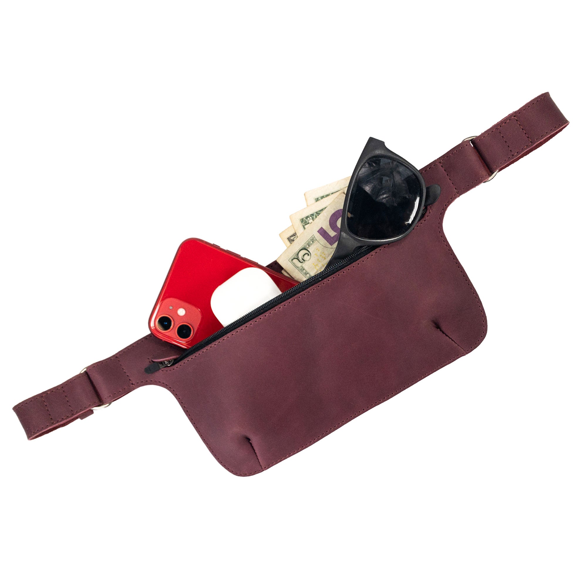 Slim Fanny Pack by Hide & Drink featuring an open pocket with cash and a phone visible, emphasizing practicality and style. This full grain leather fanny pack is artisan-made in Oaxaca Mexico.