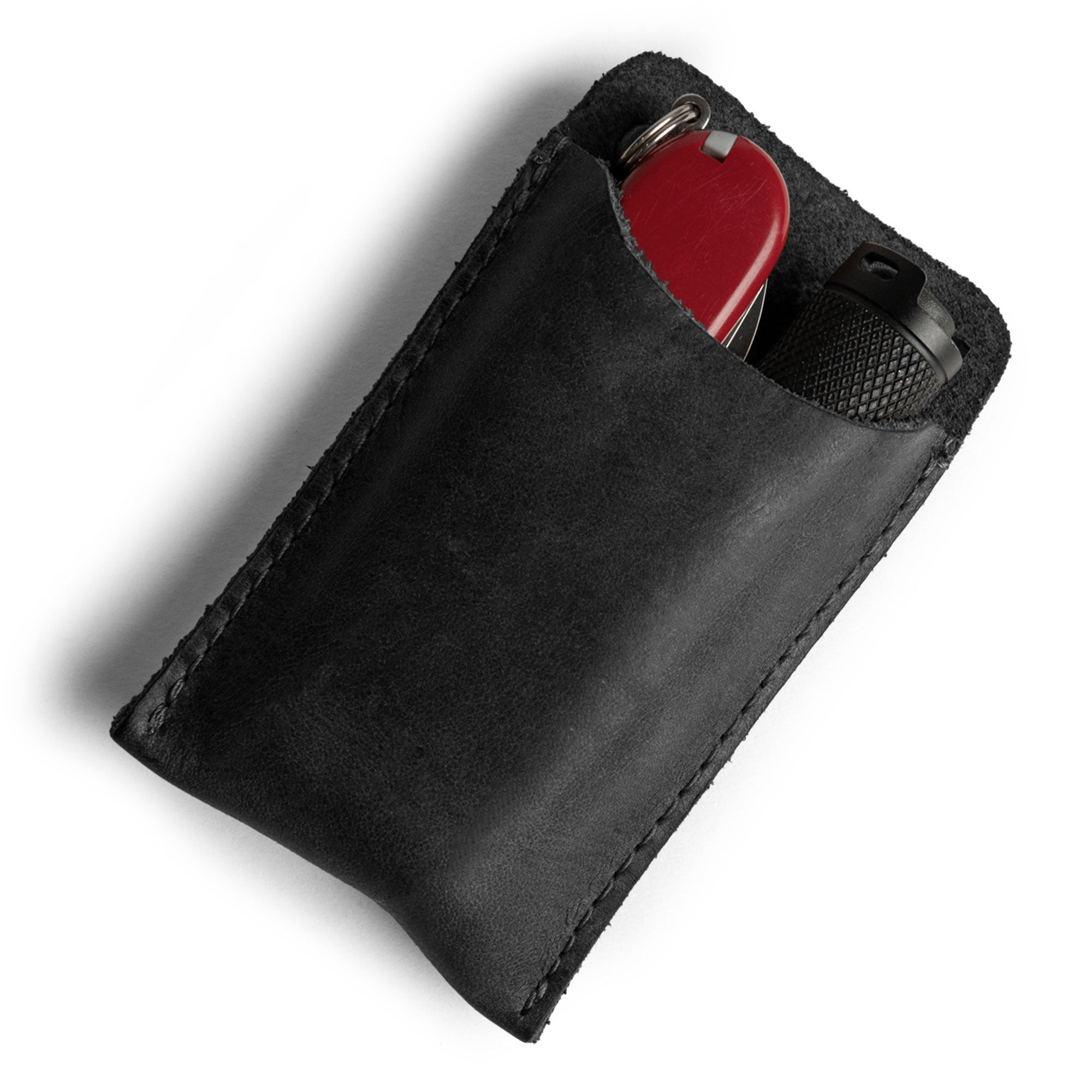 A close-up view of Hide & Drink's Multitool Pocket Sleeve EDC, made from premium black leather, ideal for multitools and small gadgets. This small tool organizer reflects the artisan methods and quality craftsmanship from La Antigua Guatemala.
