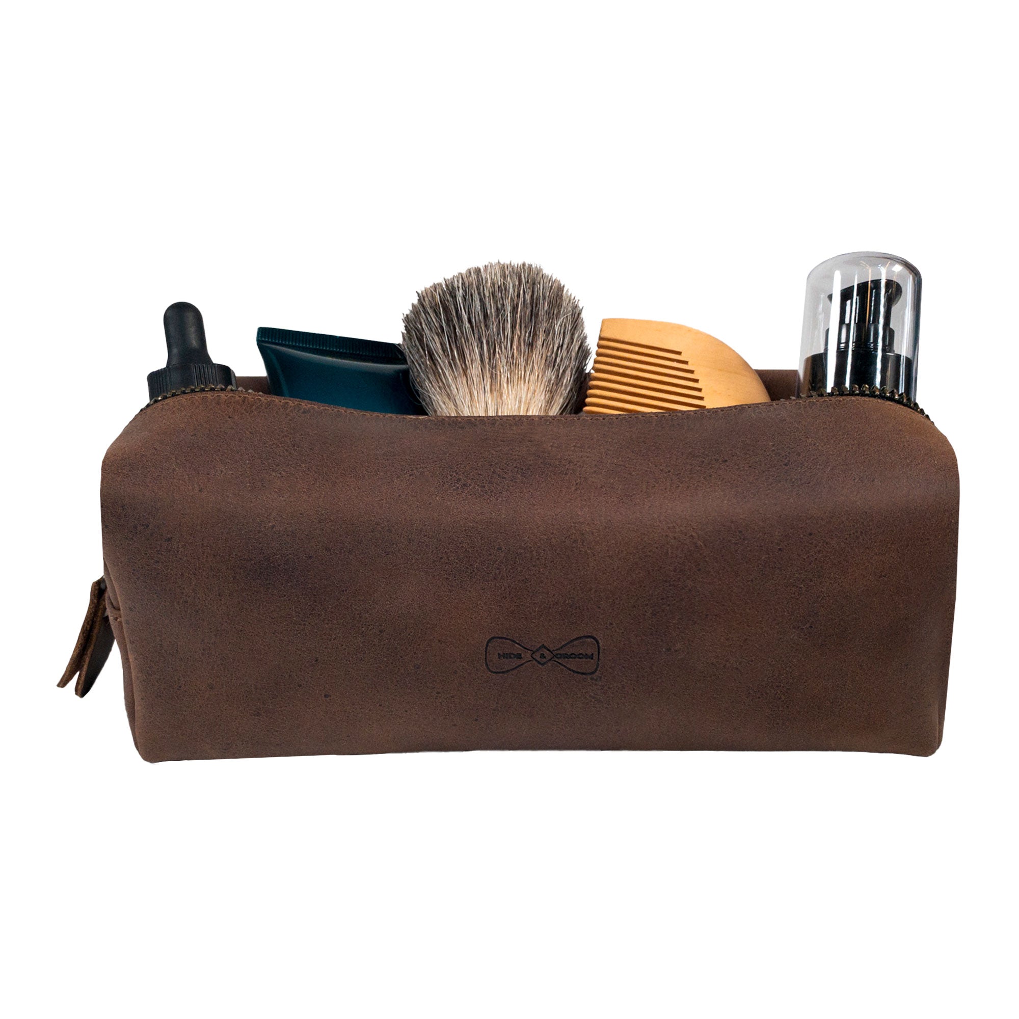 Rectangular Toiletry Bag for Groomsmen by Hide & Groom, filled with grooming products like a brush and hair products. An ideal storage solution for best men and bachelors, showcasing artisanal, handmade quality with full grain leather craftsmanship.