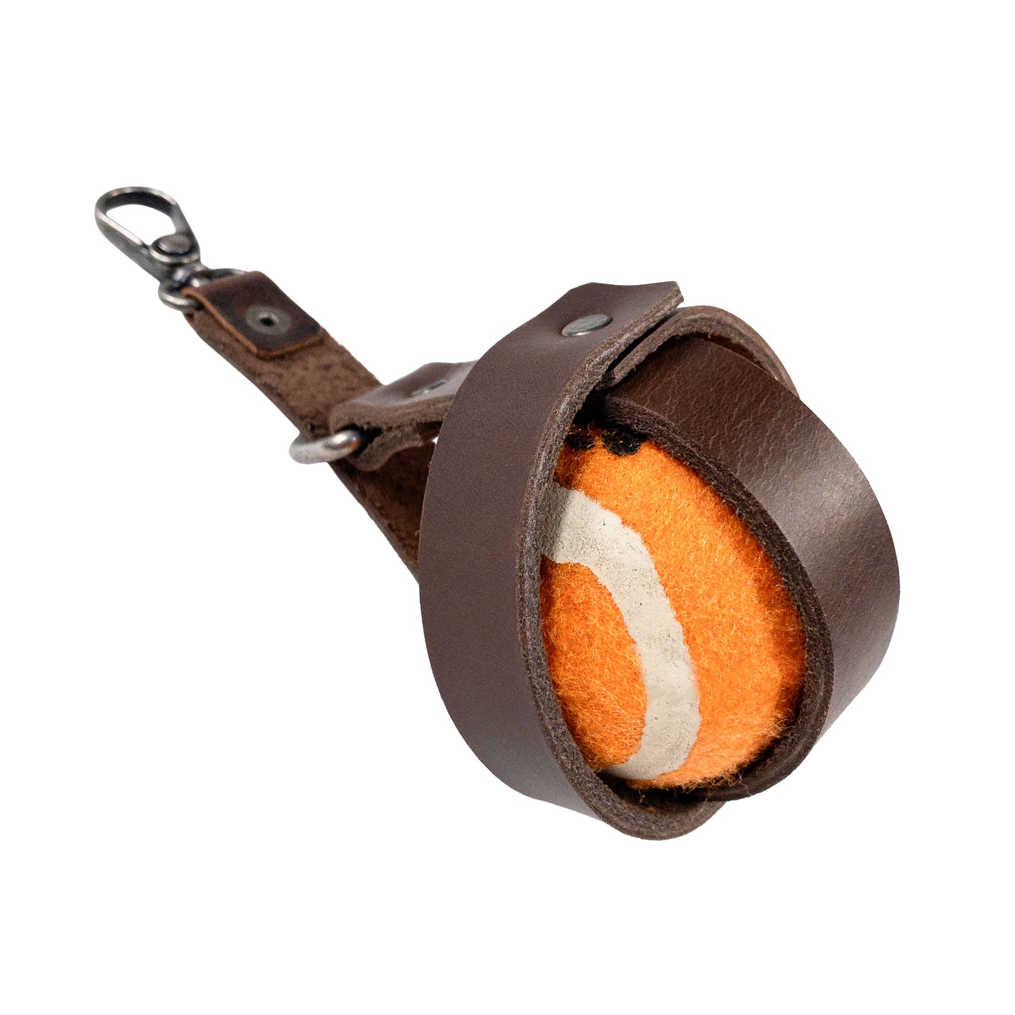Close-up of Taco Dog Dog Ball Holder, securing an orange ball within its protective leather enclosure, highlighting the quality of the Full Grain Leather. This Leash Attachment Case is perfect for Chasing Pet Toy Storage during your next outdoor outing, reflecting the Handmade, Fire Branded details from Small Batch Production in La Antigua Guatemala.