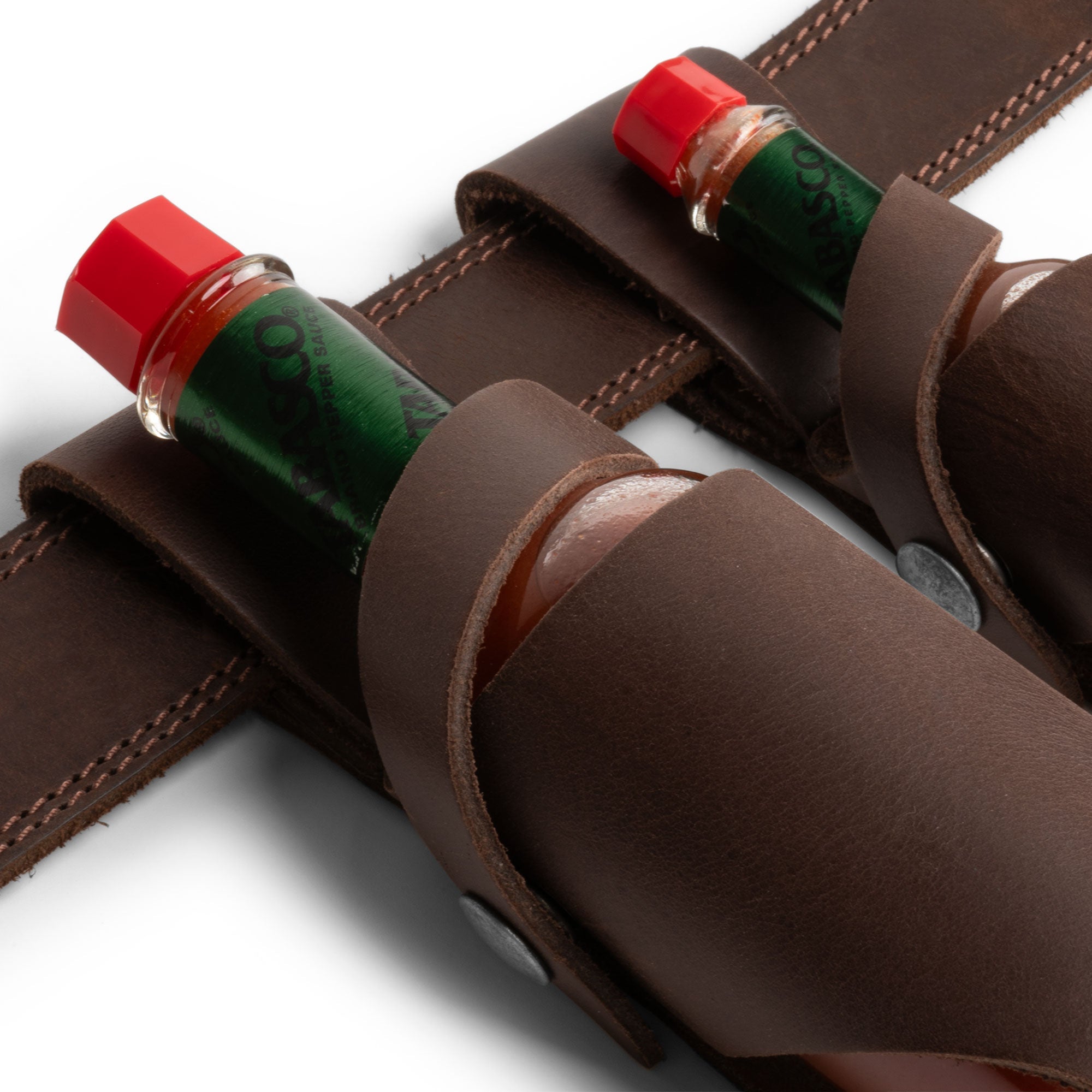 Hide & Drink Tabasco Holsters (2pk) showcasing two beautifully crafted hot sauce holsters, designed for 5oz and 2oz bottles. Ideal for Tabasco and Cholulah sauces, made from premium full grain leather, featuring small batch production, and artisanal craftsmanship, made in La Antigua Guatemala & Oaxaca Mexico.