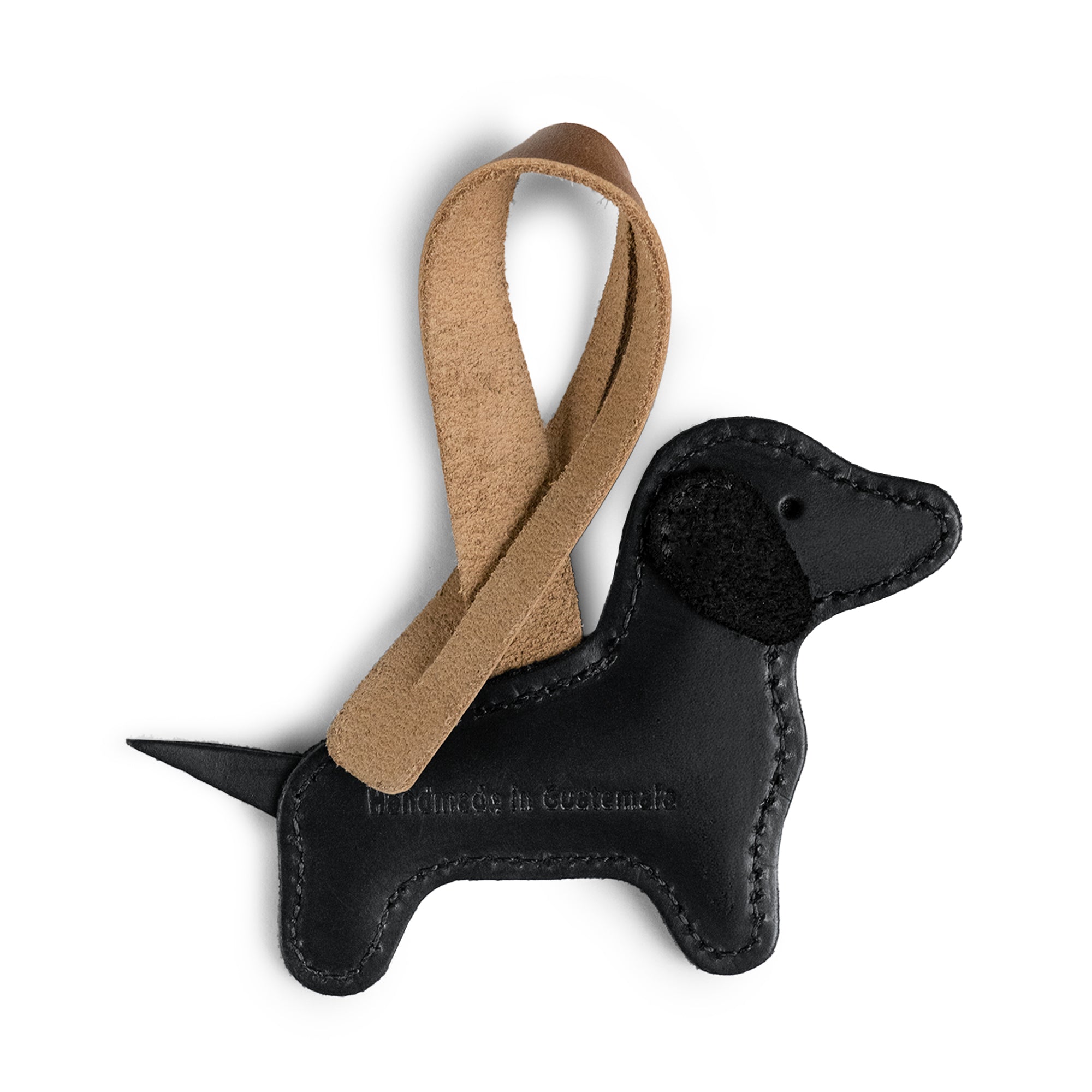 Close-up of the Hide & Drink Dachshund Bag Charm, showcasing its unique design with a leather strap. This Dachshund Bag Charm is made from full grain leather and features artisan craftsmanship perfect for enhancing handbags, purses, and backpacks. Handmade in La Antigua, Guatemala and Oaxaca, Mexico, it represents style and individuality for women looking for distinctive accessories.