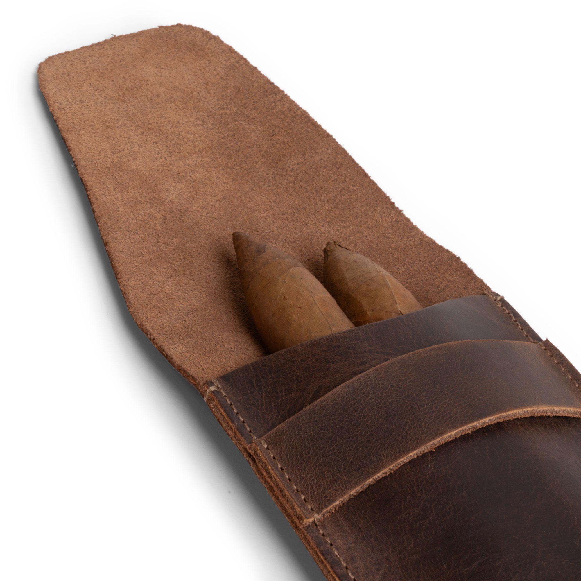 Hide & Drink Cigar Holder with a close-up view of two cigars nestled in a slim case. Ideal for three 50 ring cigars, this classic holder is made from full grain leather. Each item reflects artisan craftsmanship, hand cut and hand sewn in La Antigua Guatemala, ensuring a rustic yet durable design.