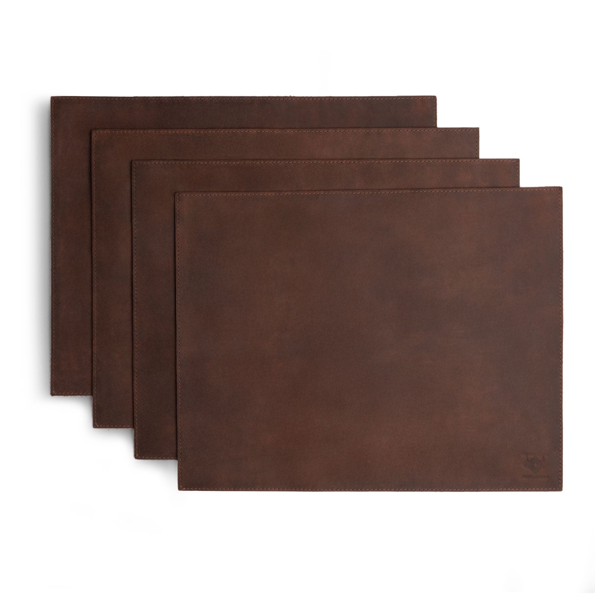 Set of 4 Rectangular Place Mats by Leather At Home, displaying a beautiful collection of genuine placemats crafted from full grain leather. These rustic mats combine functionality and style, emphasizing small batch production and handmade details.