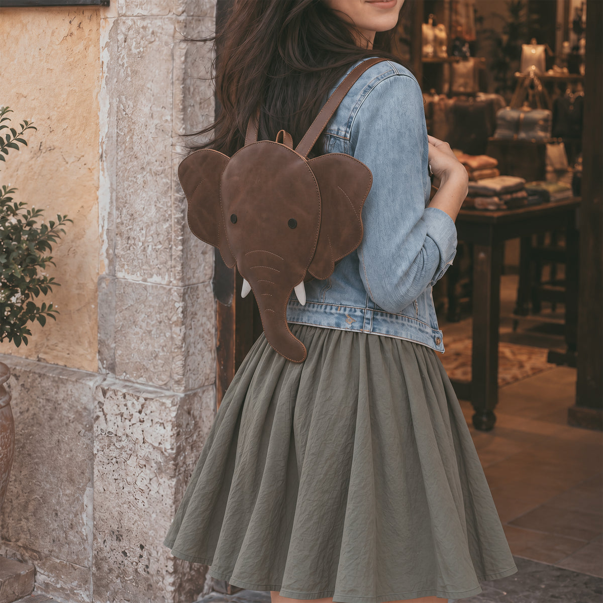 Unique Elephant-Shaped Backpack by Hide & Play, showcasing a playful elephant silhouette. This versatile Messenger Bag is crafted from Full Grain Leather, perfect as a Travel Bag for Men and Women. StockyardX emphasizes artisan quality through handmade processes in La Antigua Guatemala, ensuring durability and style.