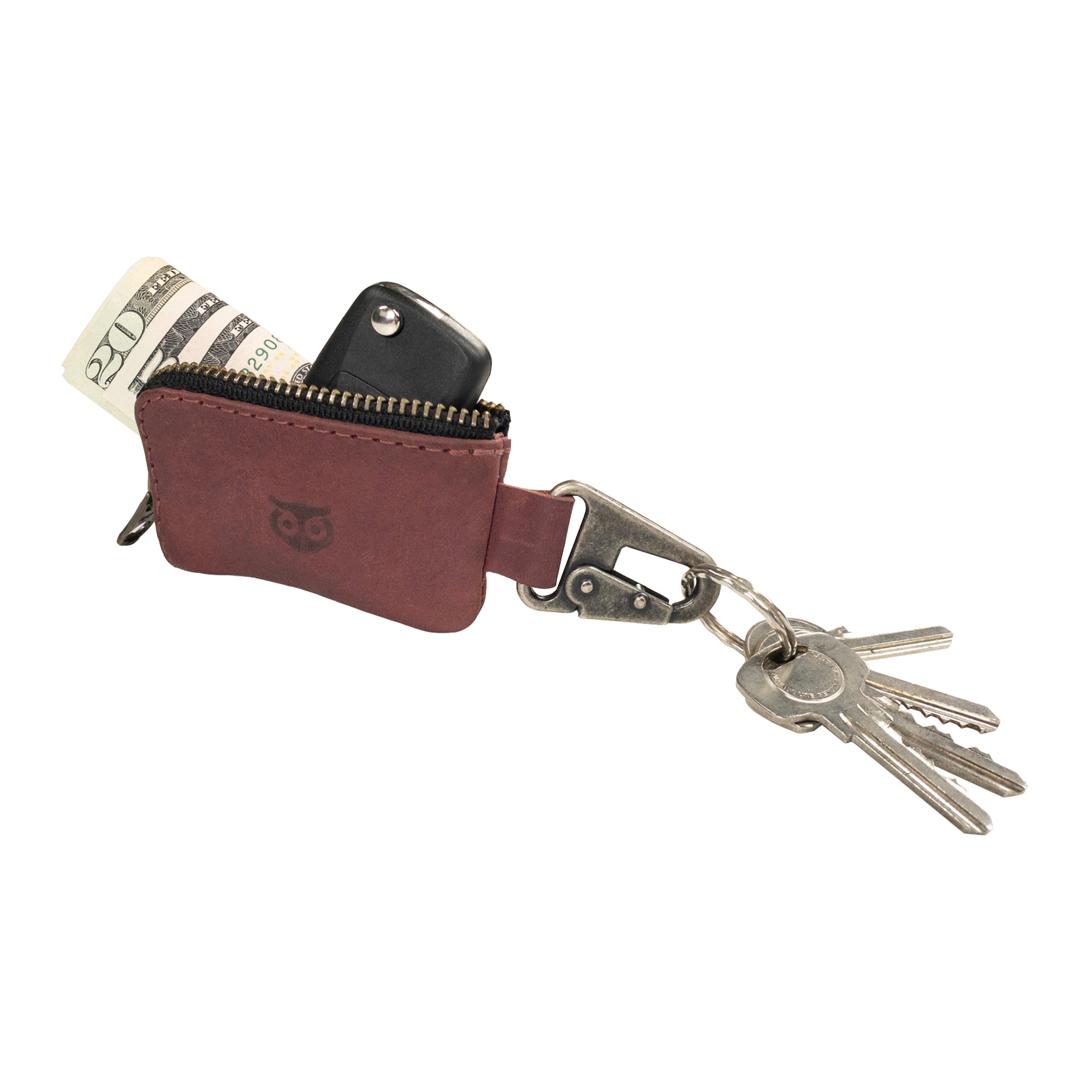 An open Car Key Holder by Hide & Drink, demonstrating its capacity for holding cash and keys seamlessly. This functional accessory also serves as a case for Headphone and charging Cables, Memory Cards, and Flash Drives. Crafted from Full Grain Leather with a Nickel Metal Clasp, embodying artisan quality from Small Batch Production in La Antigua Guatemala & Oaxaca Mexico.