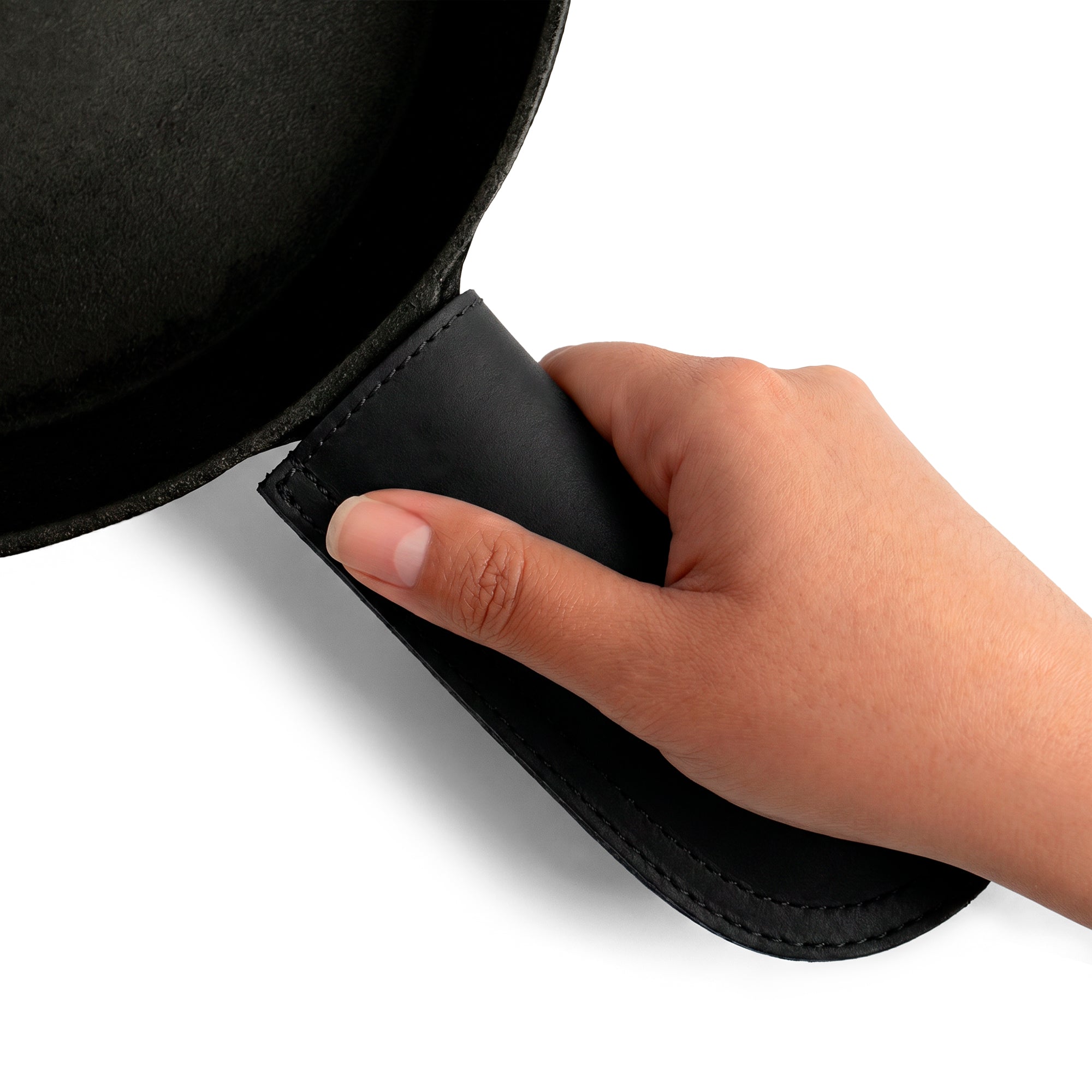 Hide & Drink Cast Iron Panhandle Cover featured on a simple background, displaying its quality. This artisan hot handle protector combines the safety of full grain leather with double stitching, and it seamlessly slides onto metal skillet grips. Handmade in La Antigua Guatemala & Oaxaca Mexico, it's a must-have for cooking enthusiasts.