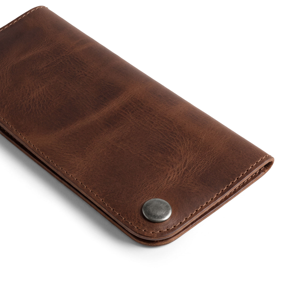 Showcasing the Brown Double Snap Folio Wallet by Hide & Drink, a handcrafted full grain leather accessory designed for style and practicality. This rectangular flat bill holder with card slot serves as a night bag and travel accessory, perfect for anyone seeking quality. Artisan made in La Antigua Guatemala & Oaxaca Mexico, it features small batch production with meticulous attention to detail.