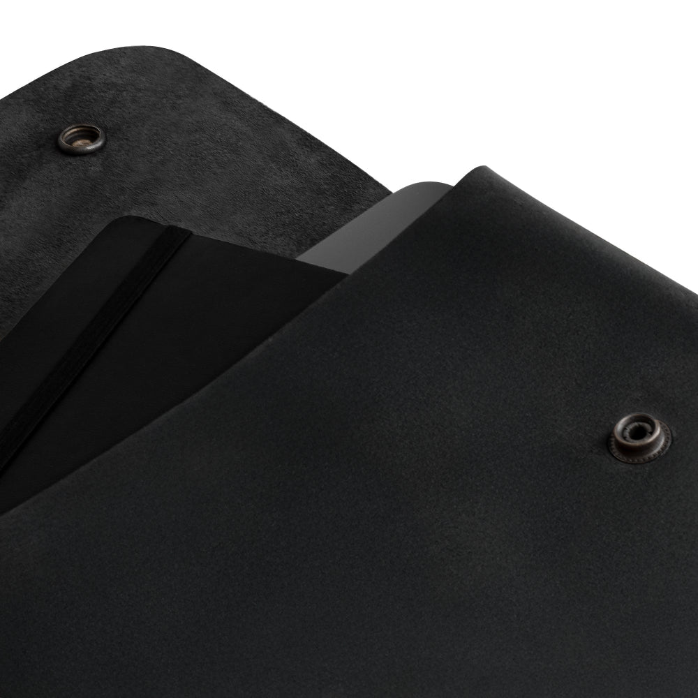 Showing Hide & Drink's Vintage Folder Holder stylized on a creative background, emphasizing its Handmade Leather quality. This Document Holder is designed with an elegant vintage envelope look made from Full Grain Leather, portraying the craftsmanship involved in Small Batch Production from La Antigua Guatemala & Oaxaca Mexico.