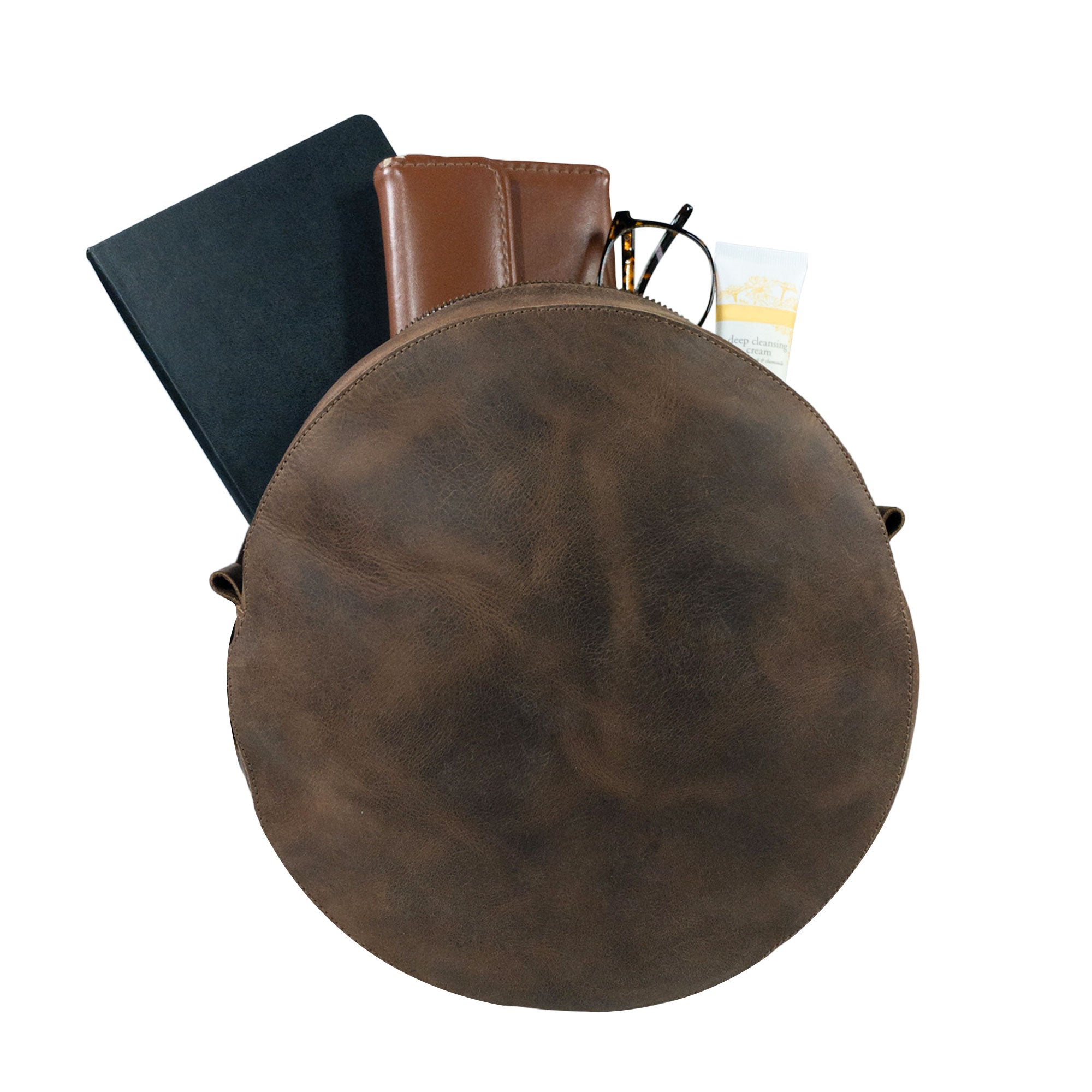 Open view of Heather's Circular Backpack, showcasing the spacious interior. This full grain leather travel accessory is perfect for carrying essentials, designed as a casual daypack with adjustable straps, all crafted by artisans through small batch production in La Antigua Guatemala & Oaxaca Mexico.