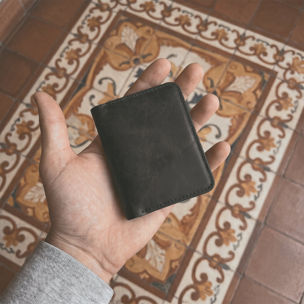Bi-Fold Card Wallet Diagonal by Hide & Drink with cards displayed in a sleek black design, demonstrating its capacity and practical use as a cash organizer, made from premium full grain leather.