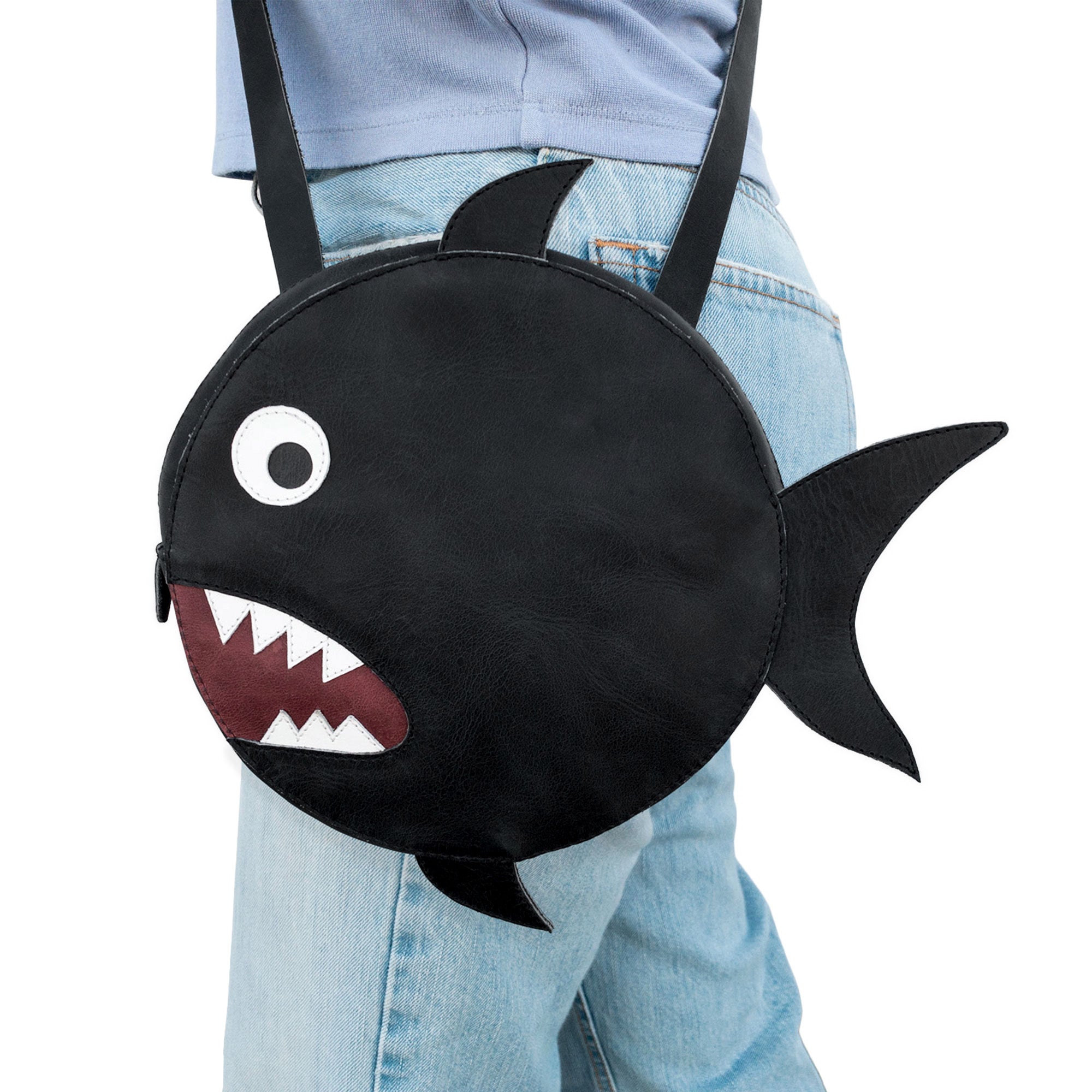 Worn casually, Tudi Frudi's Piranha-Shaped Shoulder Bag makes a statement. This messenger-style Piranha-Shaped Circular Shoulder Bag is crafted from Full Grain Leather, perfect for those seeking a unique, artisan touch in their accessories, highlighting its handmade nature from La Antigua, Guatemala.