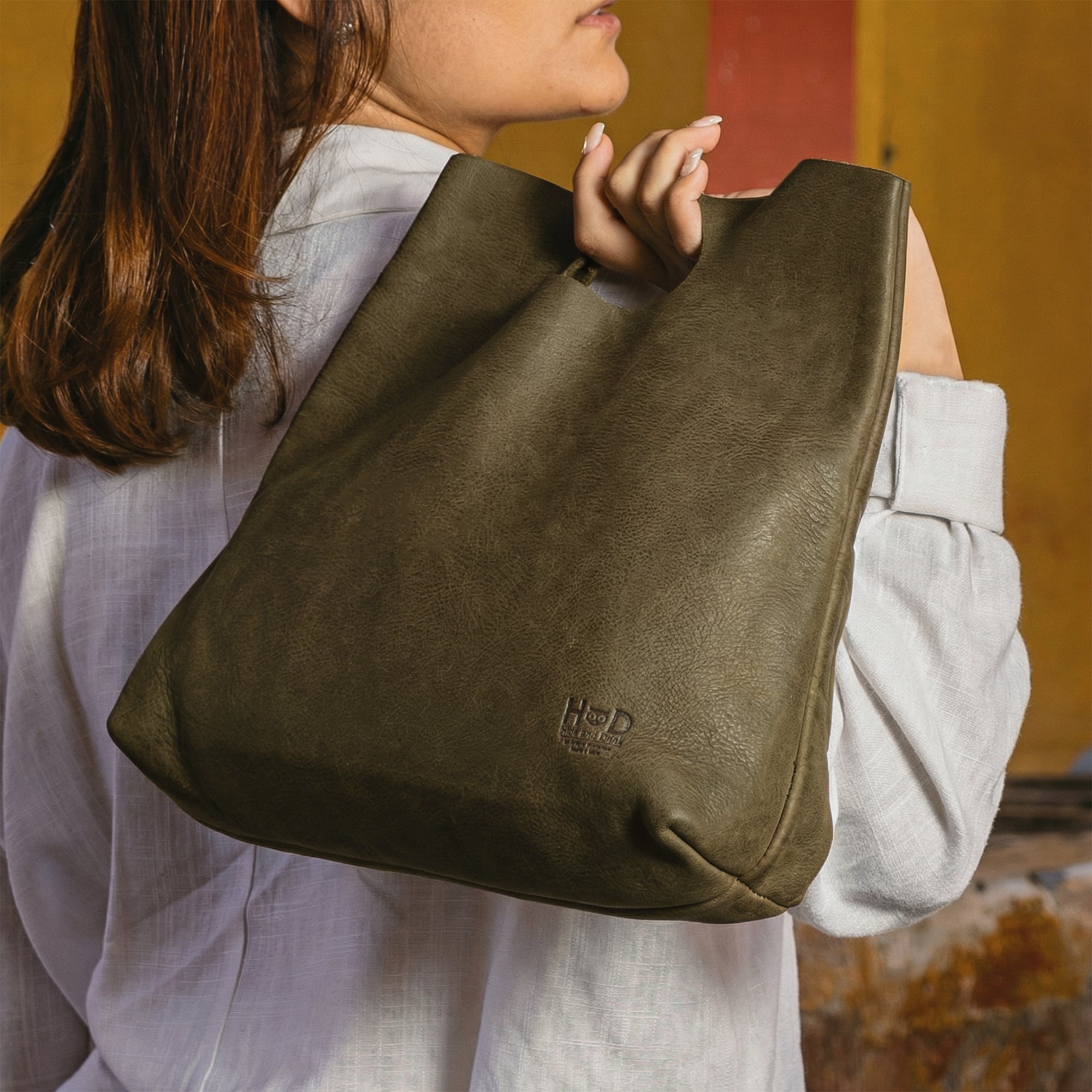 An overhead shot of the Minimalist Boho Handbag by Hide & Drink filled with everyday essentials. This Minimalist Handbag for Women serves as a practical Tote Bag, made from rustic Full Grain Leather, reflecting StockyardX‚Äôs commitment to artisan craftsmanship through Small Batch Production and Hand Cut techniques, made in La Antigua Guatemala & Oaxaca Mexico.