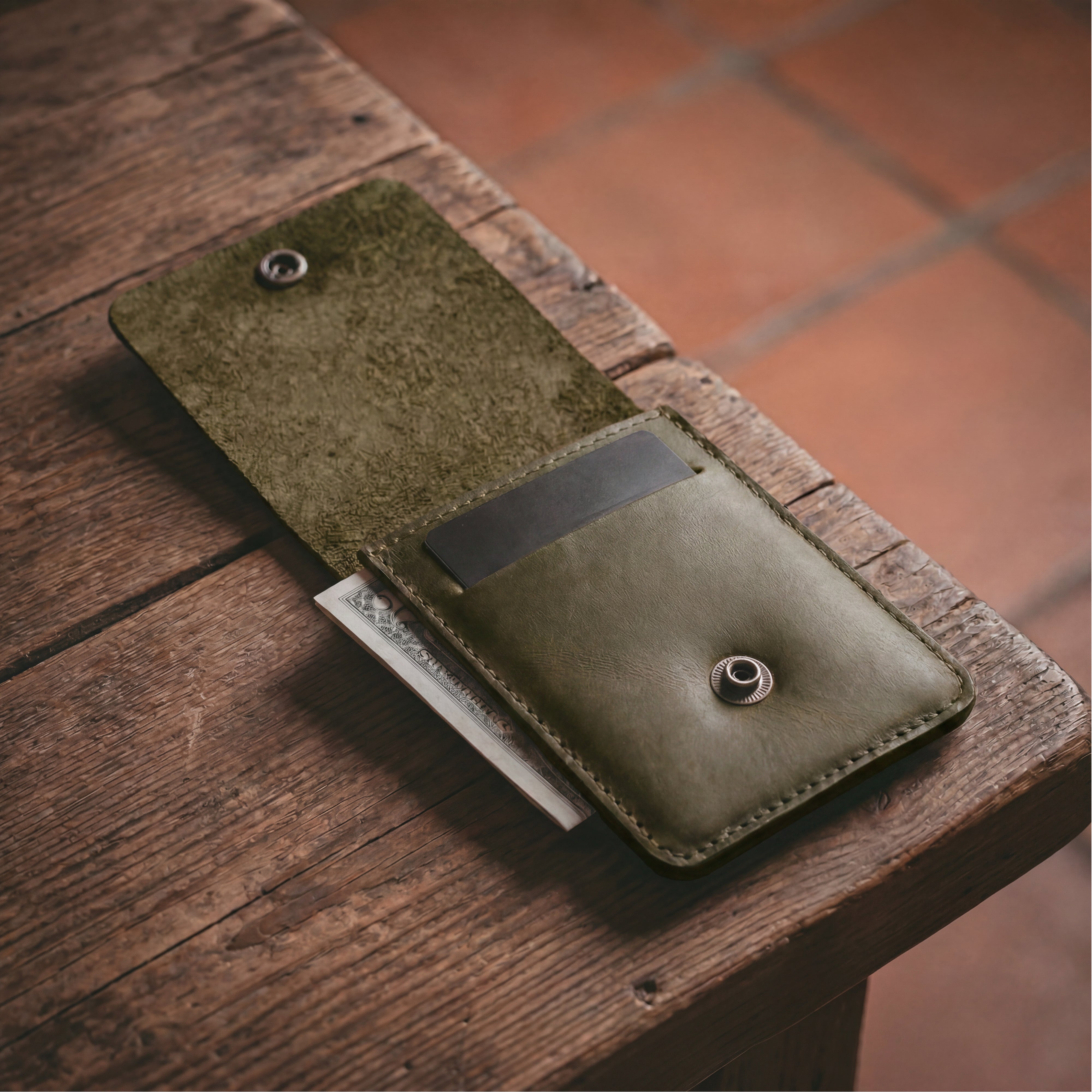 Interior view of the green Vertical Wallet by Hide & Drink, showcasing storage for cards and cash. This Vertical Front Pocket Wallet with Card Slot enhances compact storage solutions, crafted from premium full grain leather utilizing small batch production techniques, hand cut, and hand sewn carefully with fire branded elements. Handmade in La Antigua Guatemala & Oaxaca Mexico.