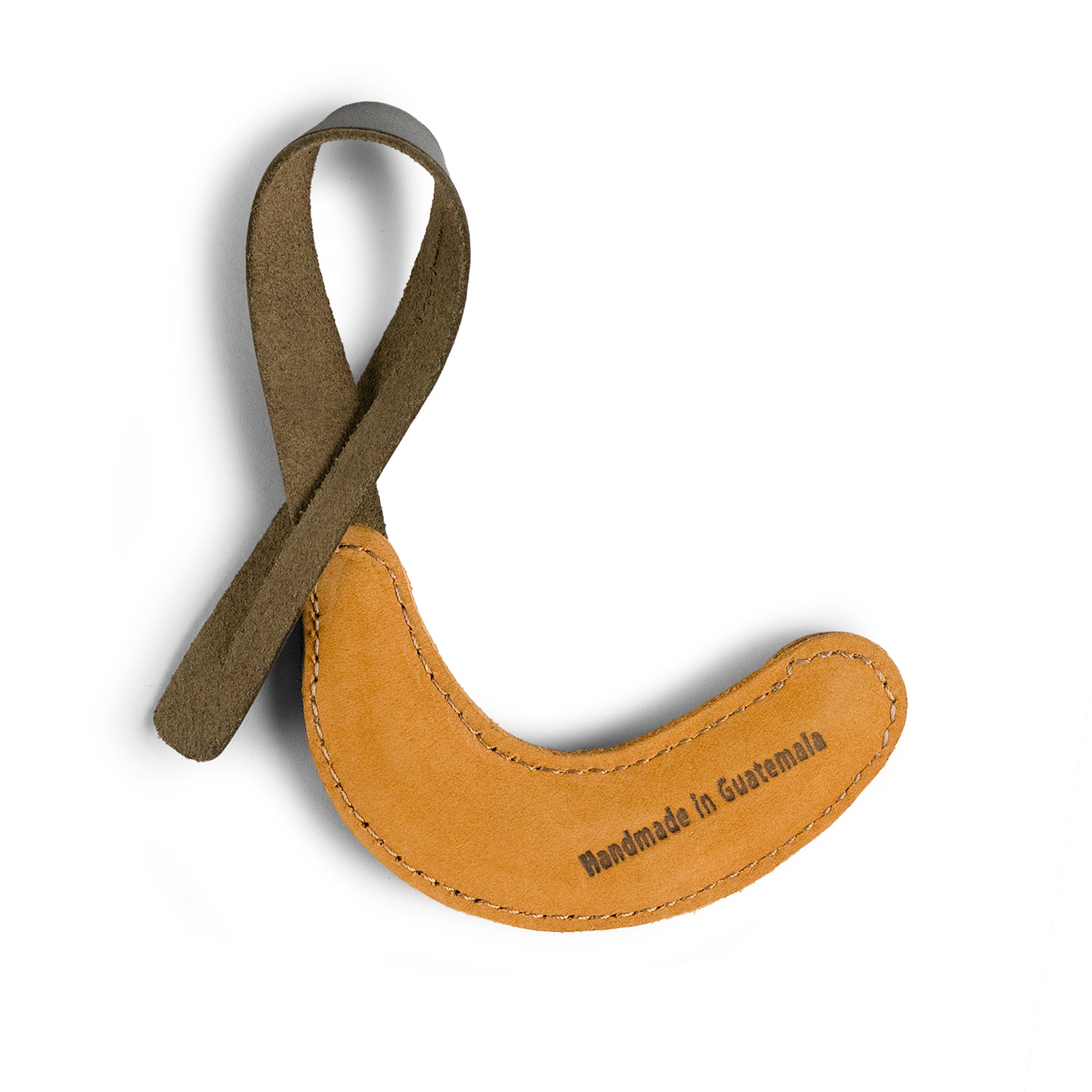 Close-up of the Hide & Drink Banana Bag Charm detailing its unique shape and stitching. This charming full grain leather piece makes a great charm for handbags, purses, or backpacks. Handmade in La Antigua Guatemala and Oaxaca, Mexico, it showcases small batch production, hand cut, hand sewn techniques, and fire branded artisan quality.