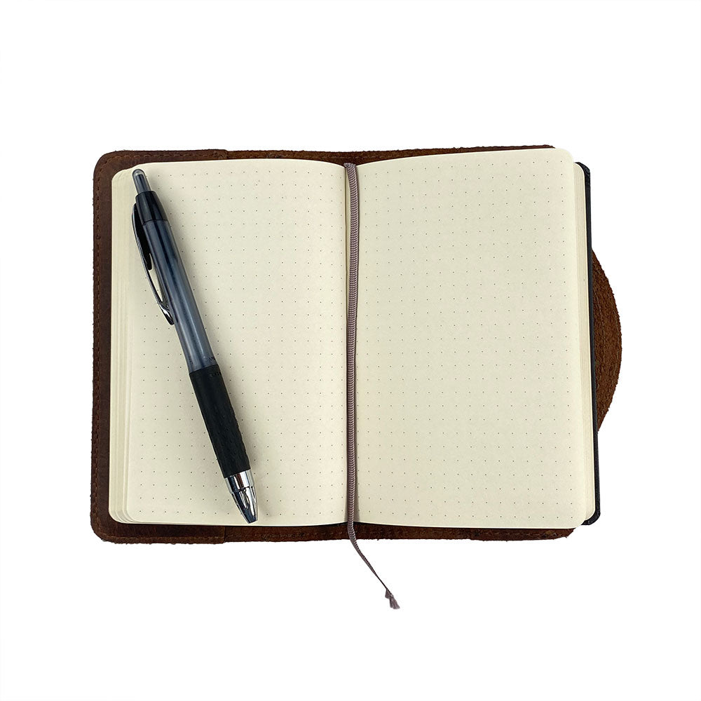 A practical display of the Hard Cover Notebook Protector (Notebook NOT Included) by Hide & Drink, emphasizing its usability. This journal cover fits Moleskine Hard Cover Sketchbook XXL Size (8.5 x 11 in.), Notebook NOT Included, made from Full Grain Leather that represents StockyardX’s excellence through small batch production, including hand cut, hand sewn, and fire branded craftsmanship from artisans. Handmade in La Antigua Guatemala & Oaxaca Mexico.