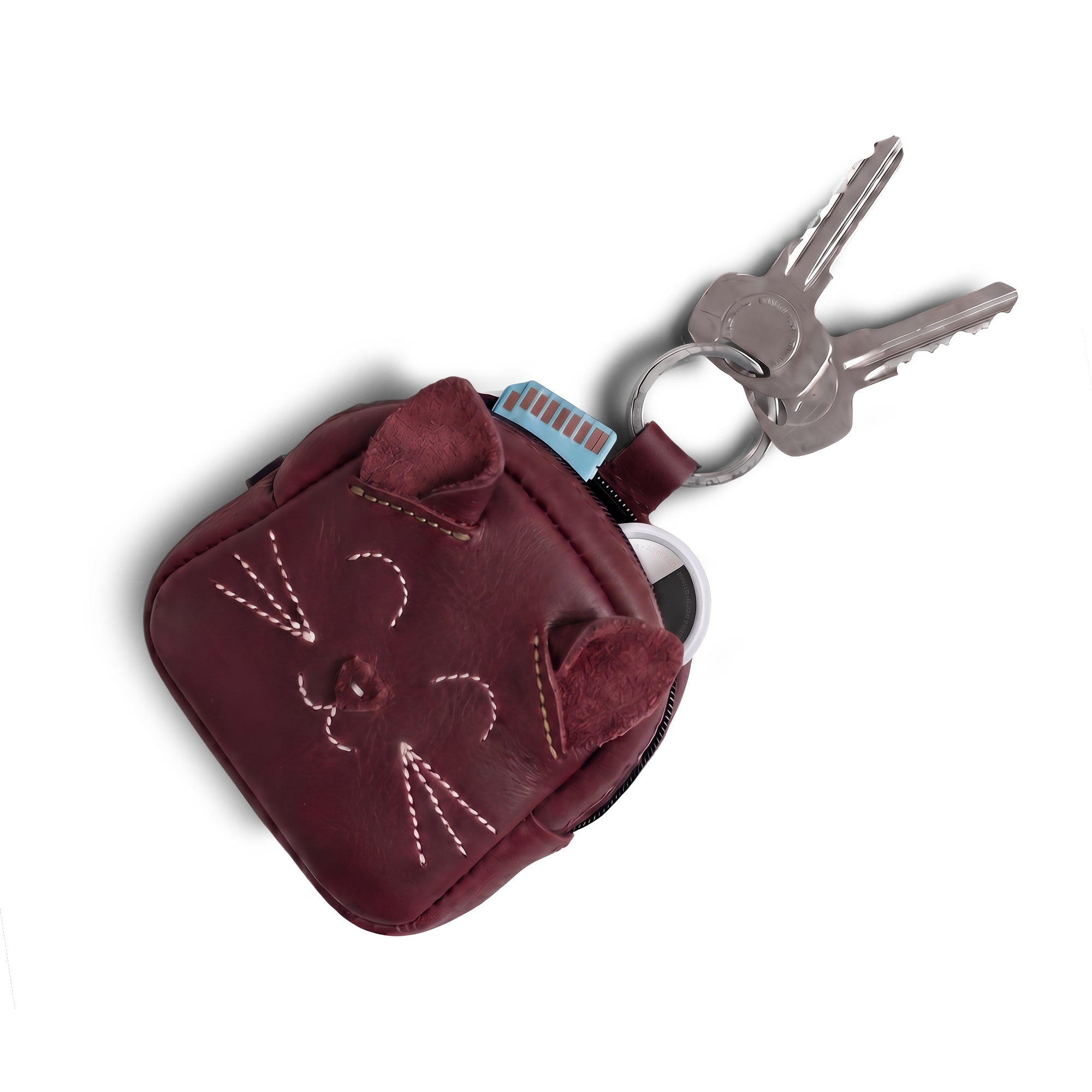 The Cheery Cat Mini Pack by Hide & Drink is shown with keys attached, emphasizing its functionality as a wallet or USB organizer. Made from Full Grain Leather, this cute pouch reflects the charm of artisan craftsmanship from La Antigua Guatemala & Oaxaca, Mexico.