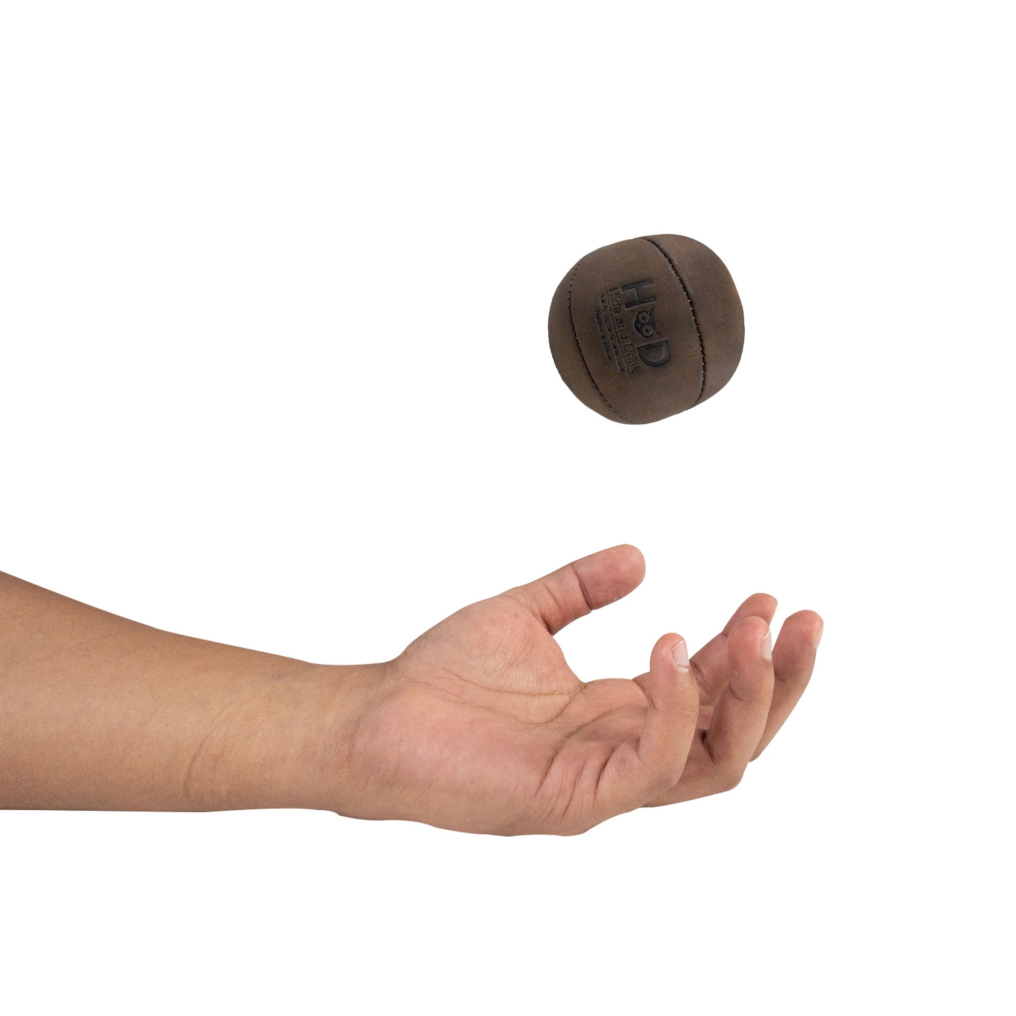 Hide & Drink Stress Ball caught mid-air, an excellent tool for relieving fidgeting and anxiety. This squishy tension accessory highlights classic style and is crafted from full grain leather. Handmade by artisans in La Antigua Guatemala.