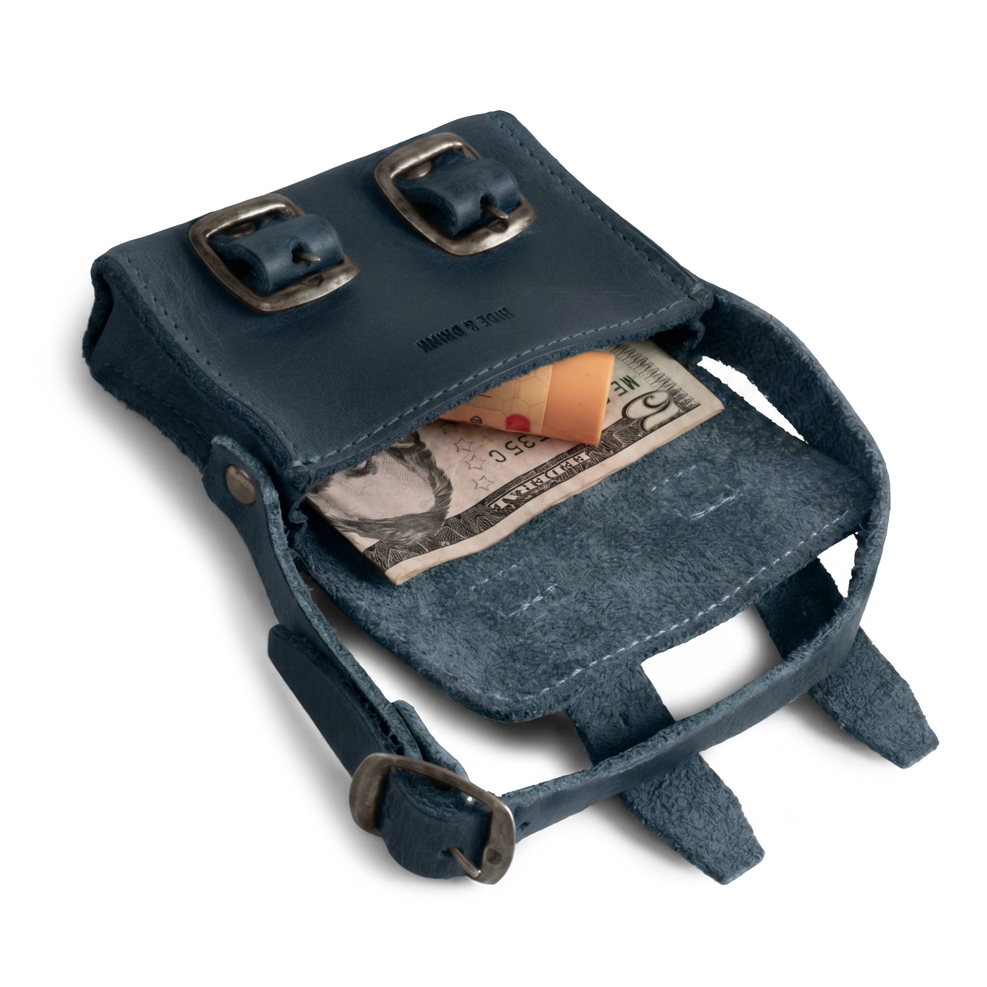 Inside view of the deep blue Tiny Messenger Bag by Hide & Drink, featuring a spacious compartment for cash and coins. This lovely Mini Messenger Bag Charm made from Full Grain Leather serves as an excellent keychain or fashionable handbag accessory, crafted by artisans in La Antigua Guatemala.