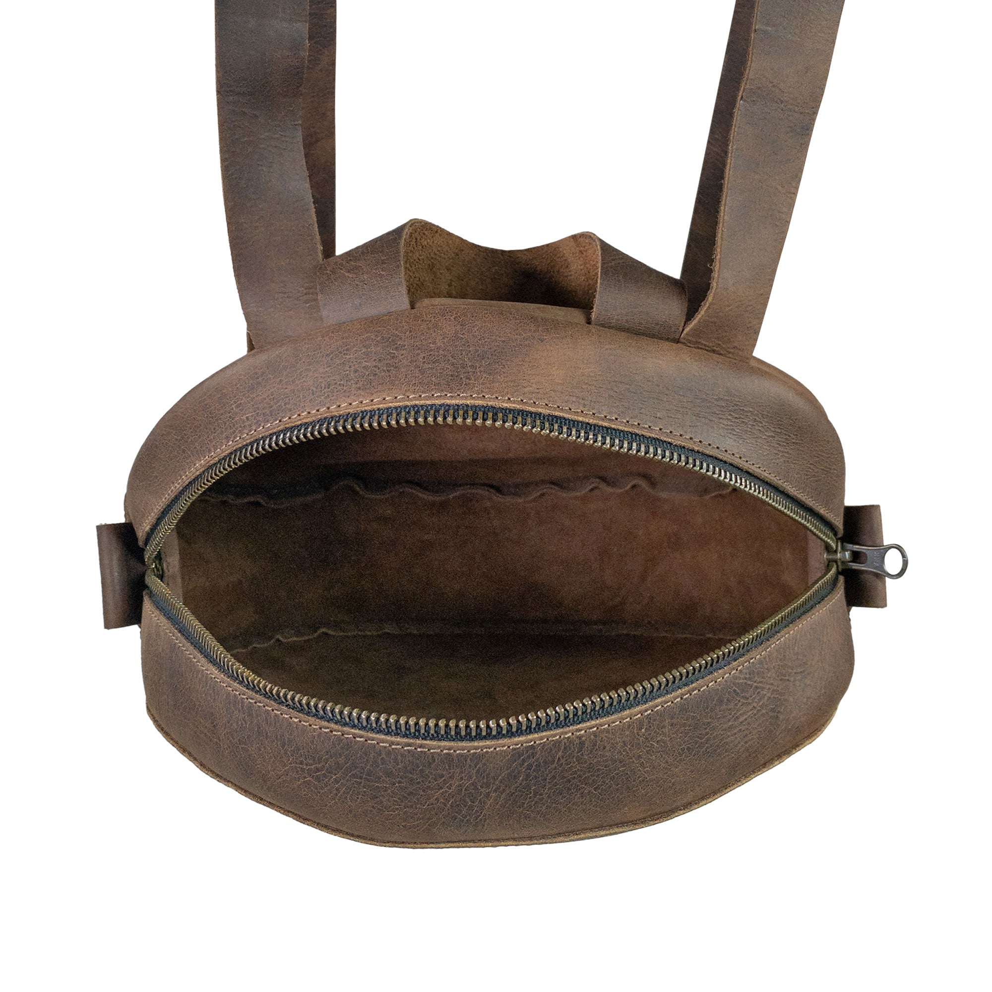 Interior view of Heather's Circular Backpack with a zipper opening, revealing the premium full grain leather lining. This travel accessory offers practicality as a casual daypack, emphasizing its handmade quality, with adjustable straps and artisanal craftsmanship in La Antigua Guatemala & Oaxaca Mexico.