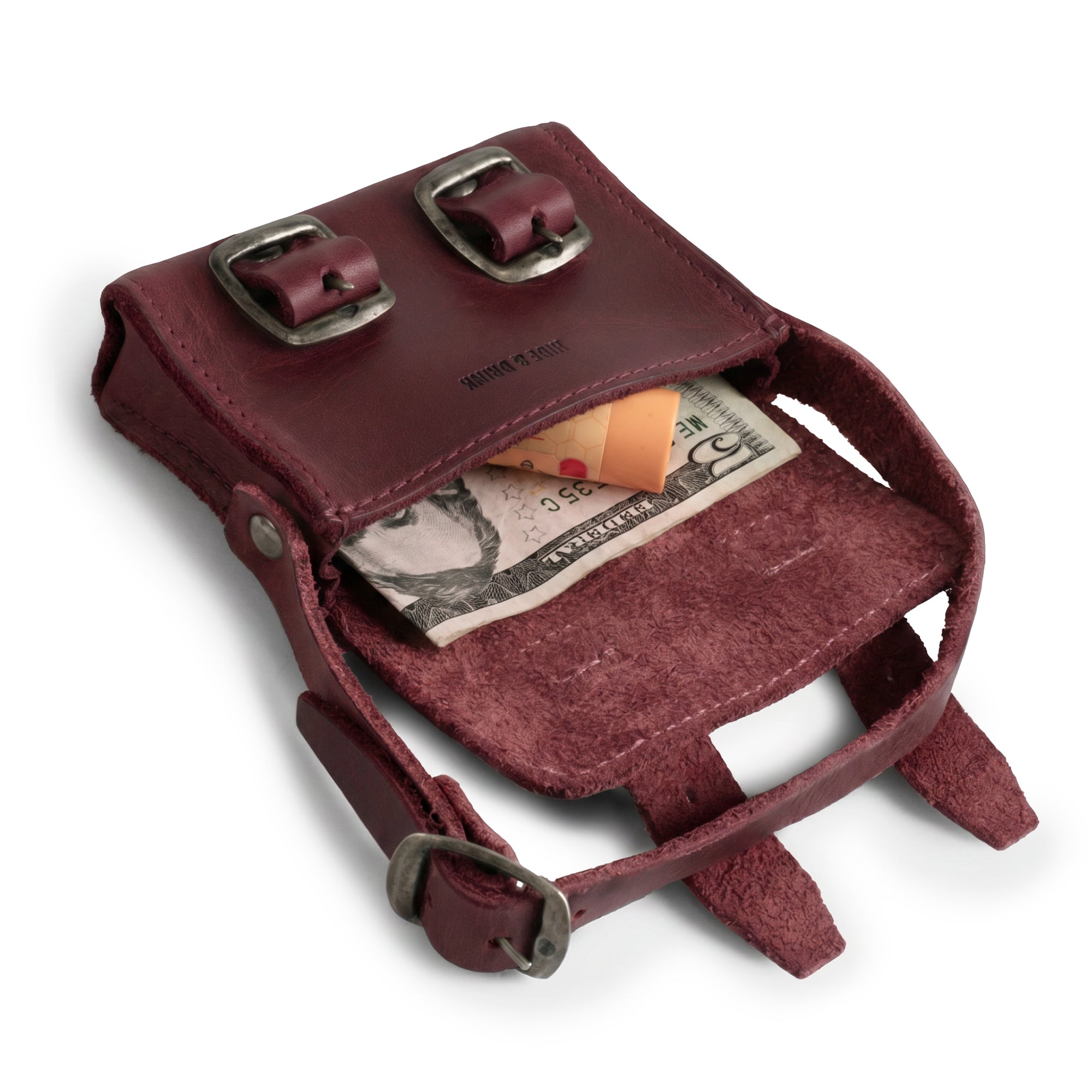 Inside view of the burgundy Tiny Messenger Bag by Hide & Drink, featuring a perfect space for cash and coins. This Mini Messenger Bag Charm made of Full Grain Leather is an excellent artisan accessory, ideal for keychain use and handcrafted in La Antigua Guatemala.