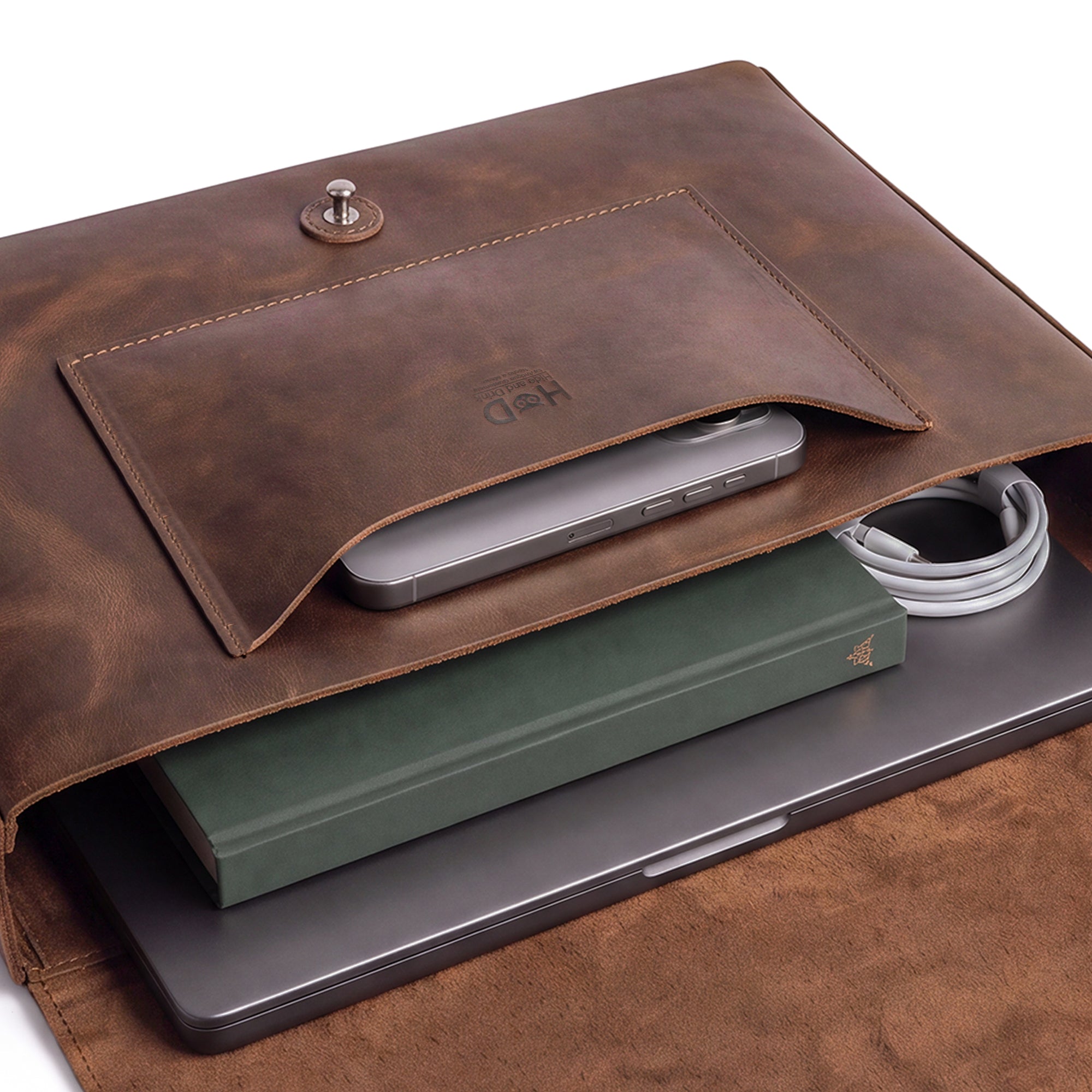 Interior view of Hide & Drink's Messenger Bag with Adjustable Strap, showing spacious storage for laptops and essentials. This travel accessory includes a messenger bag with shoulder strap made from full grain leather, combining artisan craftsmanship with small batch production, hand cut, and hand sewn details. Handmade in La Antigua Guatemala & Oaxaca Mexico.