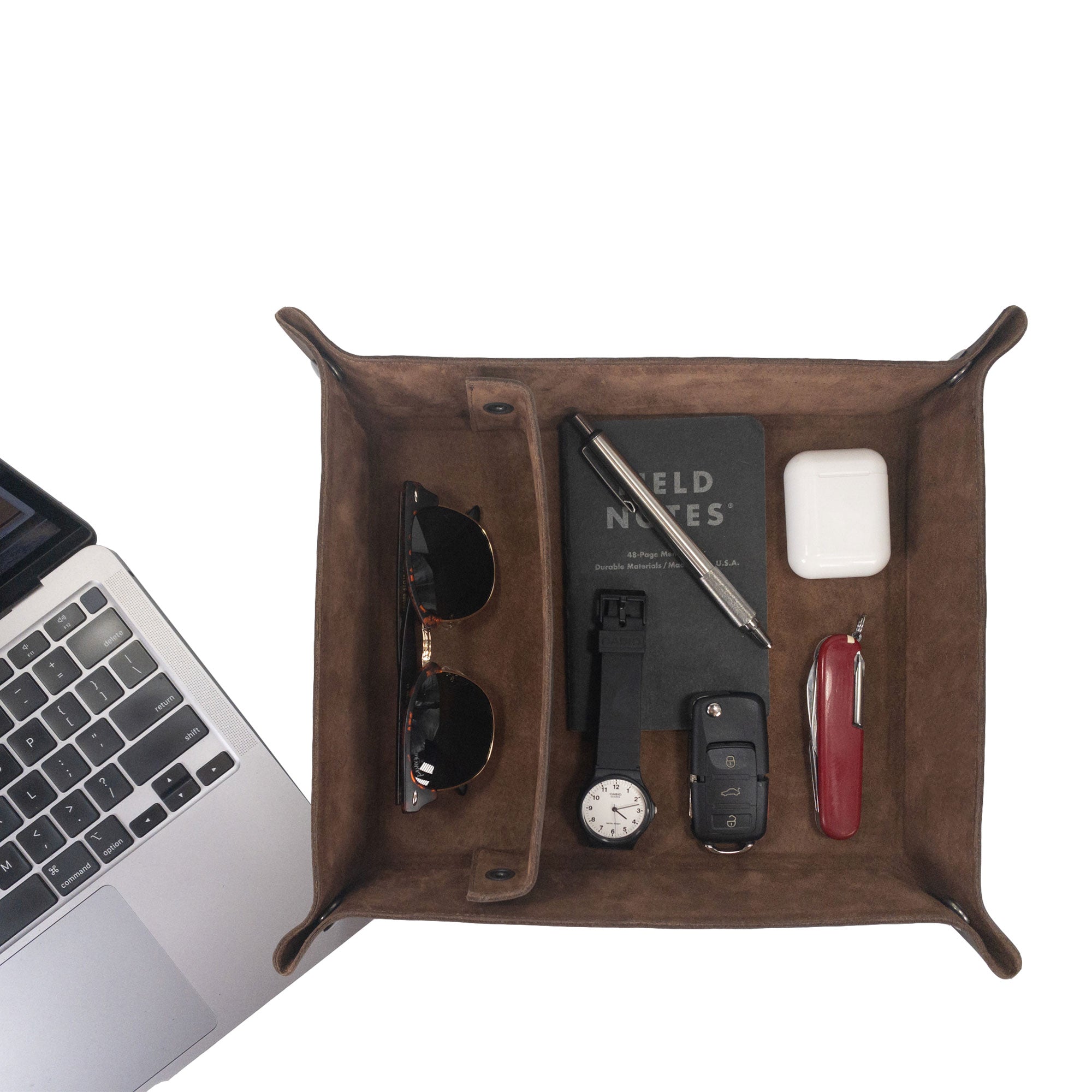 A neatly arranged top view of the Rectangular Catchall with Removable Compartment by Hide & Drink, filled with sunglasses, a notebook, and a pen. This beautiful desktop storage solution is handmade from Full Grain Leather & Sheepskin, showcasing the quality of Small Batch Production, Hand Cut, Hand Sewn, and Fire Branded artistry, crafted with care in La Antigua Guatemala & Oaxaca Mexico.