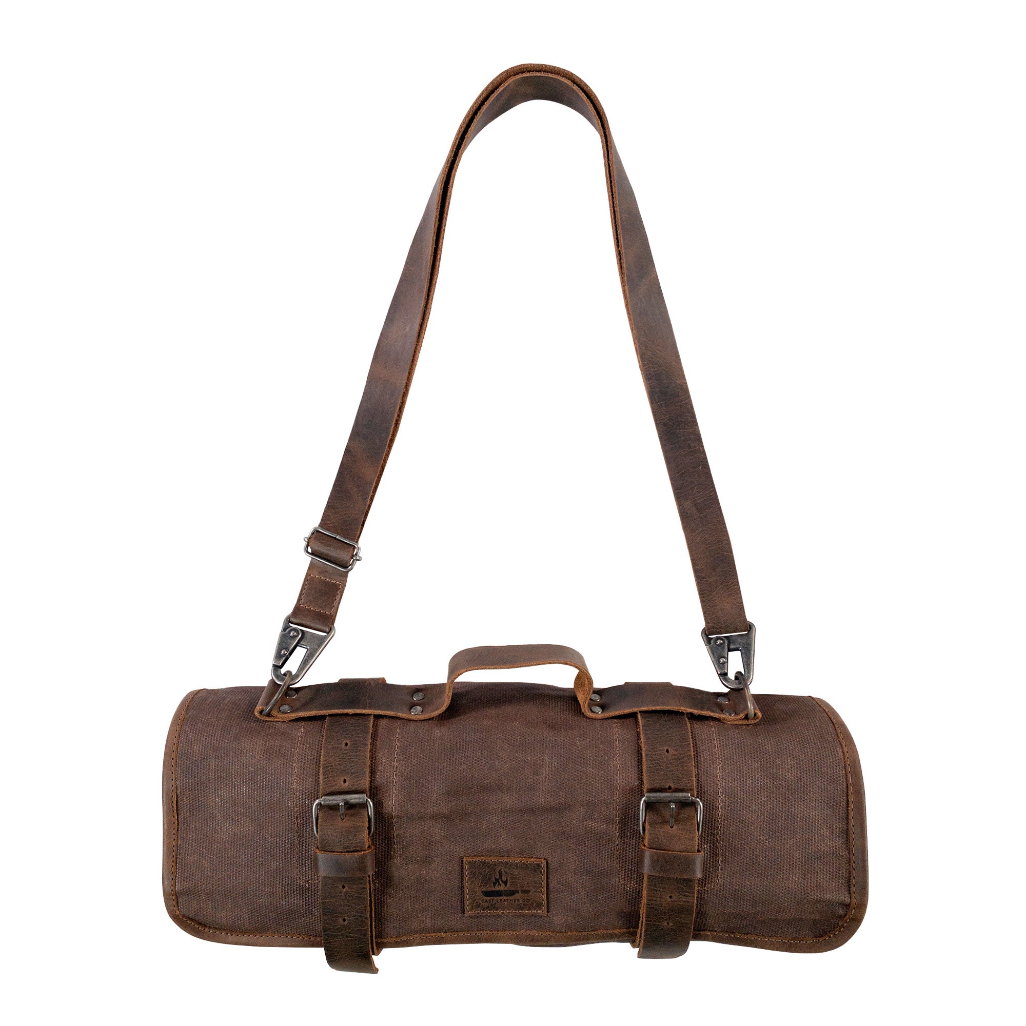 The Knife Roll with 8 Slots by Cast Leather Co. is displayed slung over the shoulder in a stylish way. This rugged travel bag combines functionality and artisanal craftsmanship, ideal for chefs and cooking enthusiasts. Made of waxed canvas and full grain leather, it showcases the essence of handmade items from La Antigua Guatemala.