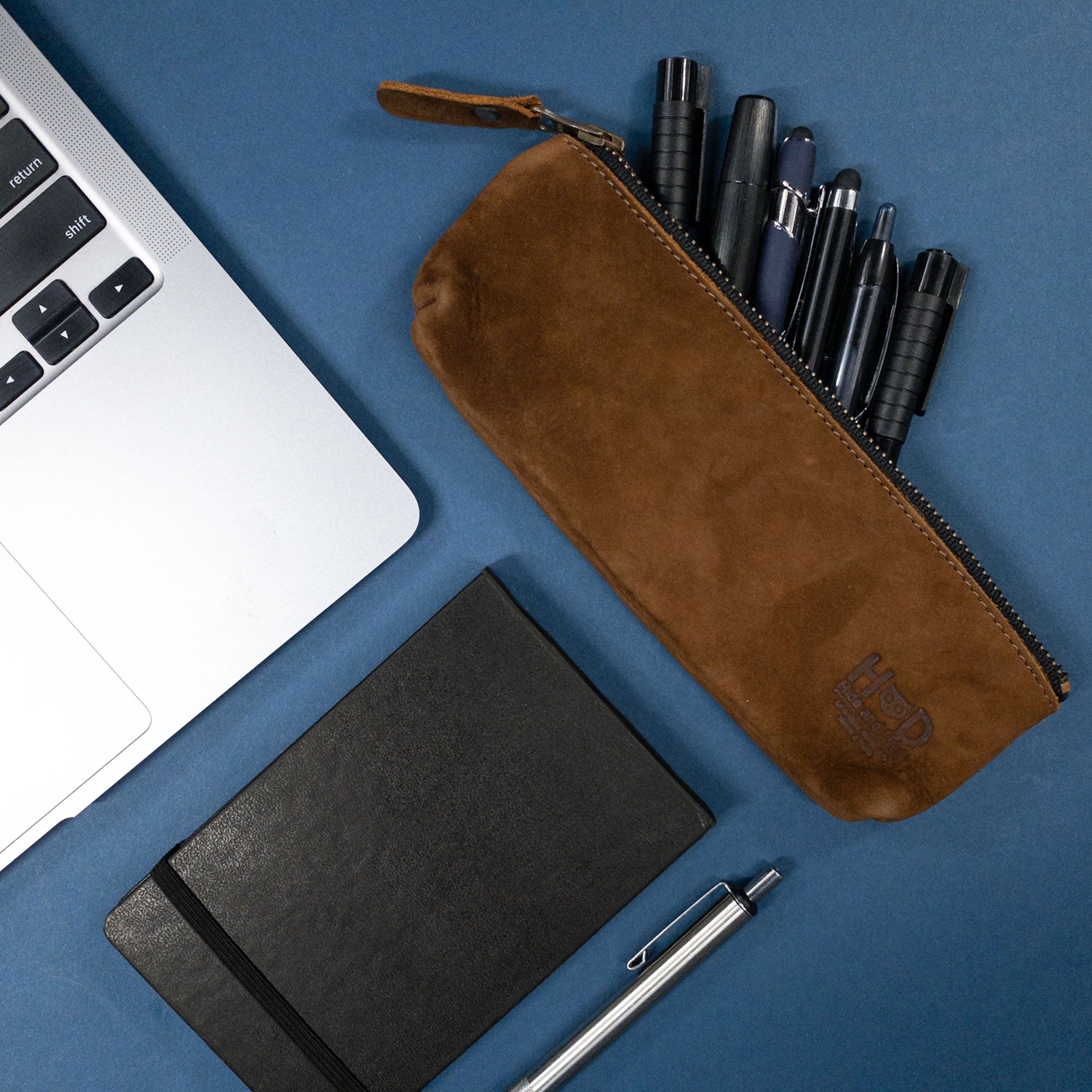 Detailed dimensions of Hide & Drink's Pencil Pouch juxtaposed with markers for size comparison. This elegant rectangular pencil case crafted from full grain leather serves as a useful pen & marker pouch for men and women, highlighting small batch production and artisan quality from La Antigua Guatemala & Oaxaca Mexico.