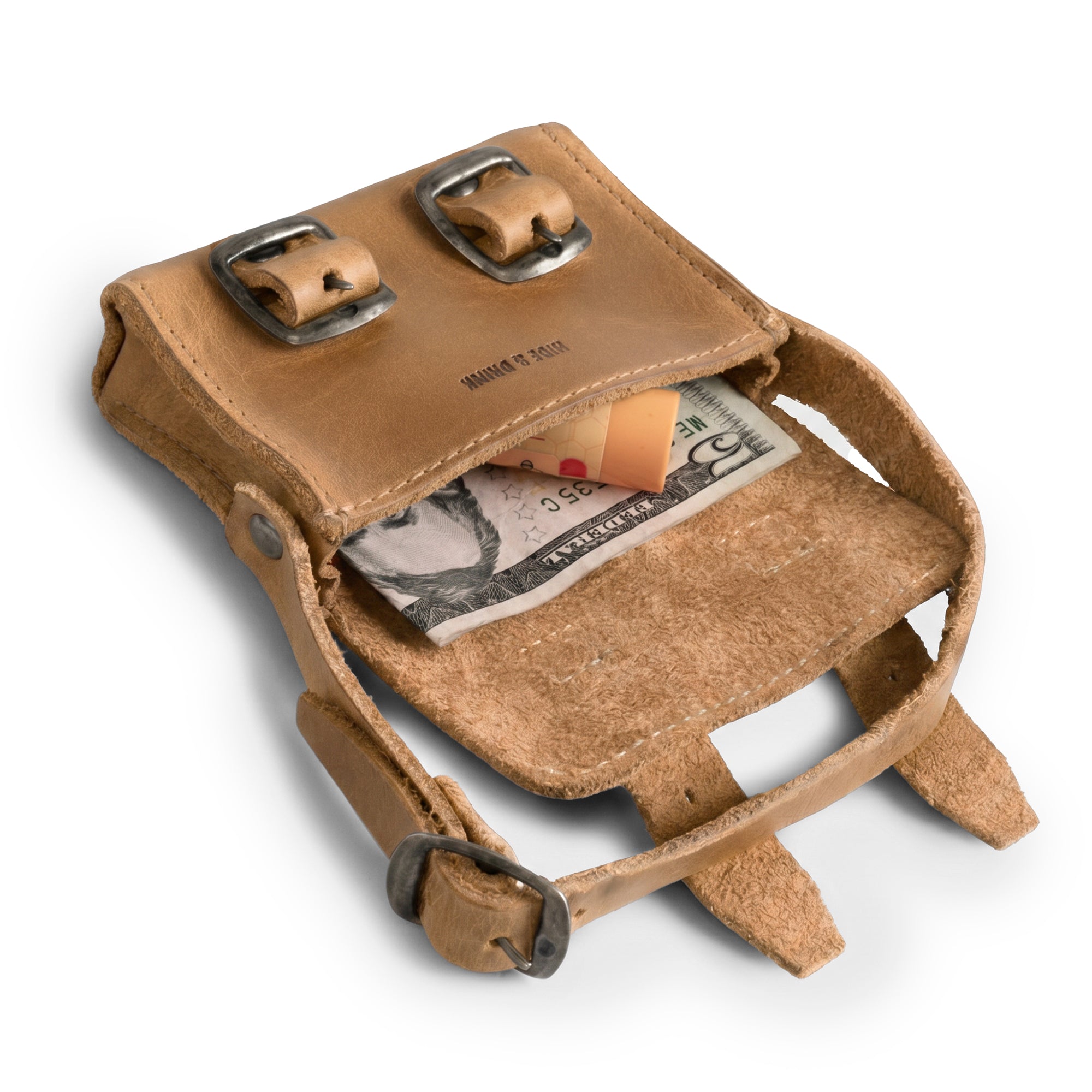 Inside view of the tan Tiny Messenger Bag by Hide & Drink, showing space for coins and cash. This delightful Mini Messenger Bag Charm made from Full Grain Leather is perfect for keychain use or as a handbag ornament, reflecting artisan craftsmanship in La Antigua Guatemala.