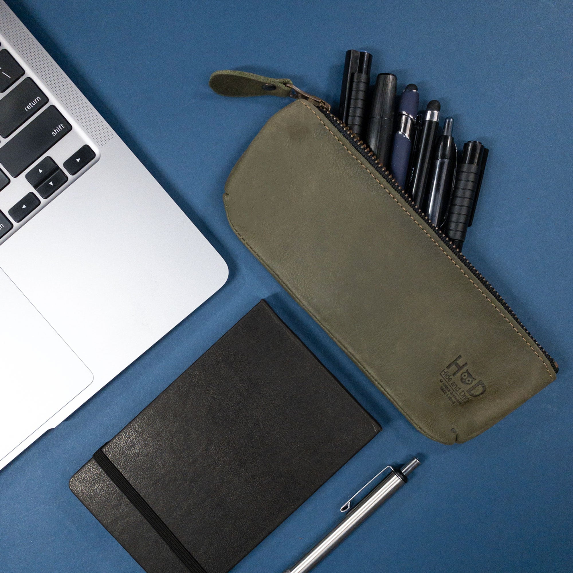 Hide & Drink Pencil Pouch with tags indicating its artisan roots, emphasizing the quality and craftsmanship in every piece. Made with durable full grain leather, this rectangular pencil case serves as a perfect pen and marker pouch for both men and women, lovingly handcrafted in La Antigua Guatemala & Oaxaca Mexico.