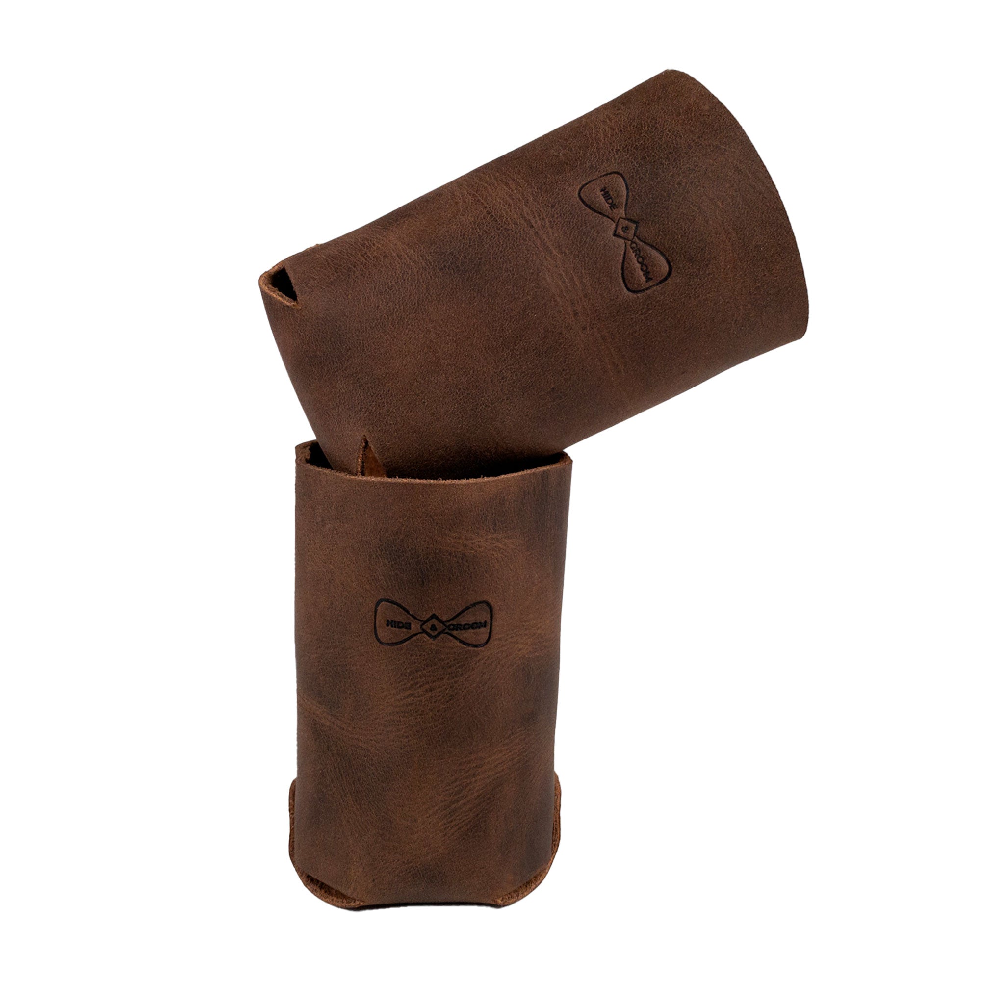 Features the Hide & Groom Beer Can Sleeve (Set of 2) in a stacked position, emphasizing their collapsible and rustic design. Ideal for weddings, these full grain leather sleeves are handmade in La Antigua Guatemala & Oaxaca Mexico, offering durable, artisan-quality protection for standard cans.