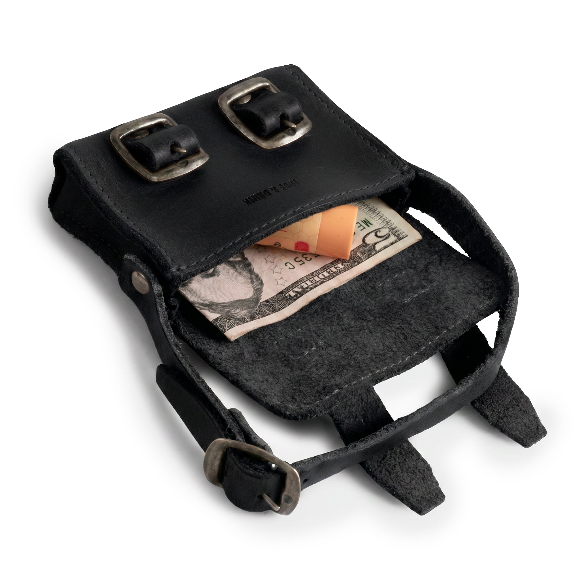 Inside view of the Black Tiny Messenger Bag by Hide & Drink, illustrating the clever design with currency and coins. A stylish Mini Messenger Bag Charm in Full Grain Leather, perfect for keychain or handbag use, hand crafted by artisans in La Antigua Guatemala.