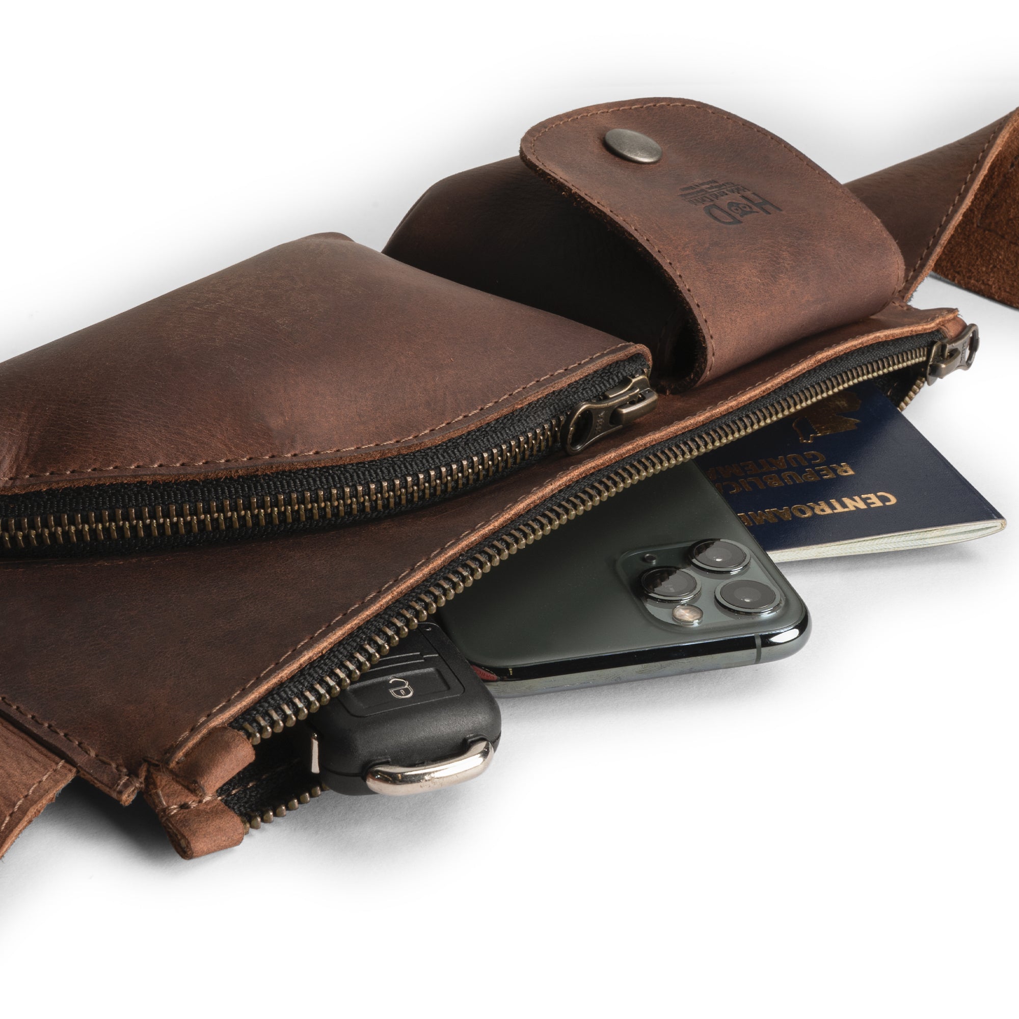 Stylish and practical, the Crossbody Multi-Pocket Bag by Hide & Drink is filled with accessories, emphasizing its ample space. This full grain leather Crossbody Bag doubles as a Messenger Bag or Shoulder Bag, making it an essential Travel Accessory. Each piece is hand cut and hand sewn, proudly reflecting the artisan traditions from La Antigua Guatemala & Oaxaca Mexico.