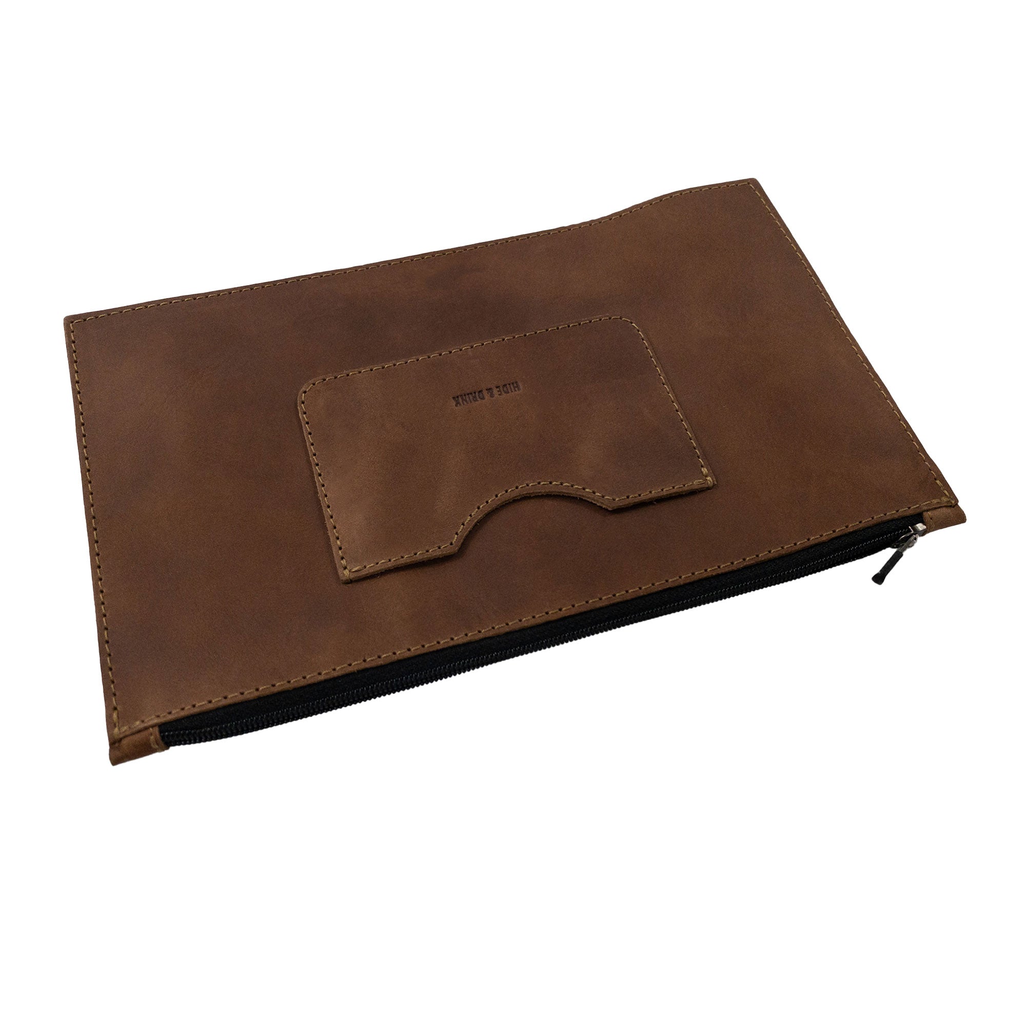 Side view of a brown rectangular zippered handbag by Hide & Drink emphasizing its sleek design. This female purse features a card slot and is made from full grain leather, highlighting artisan dedication through small batch production and handcrafted details in La Antigua Guatemala & Oaxaca Mexico.