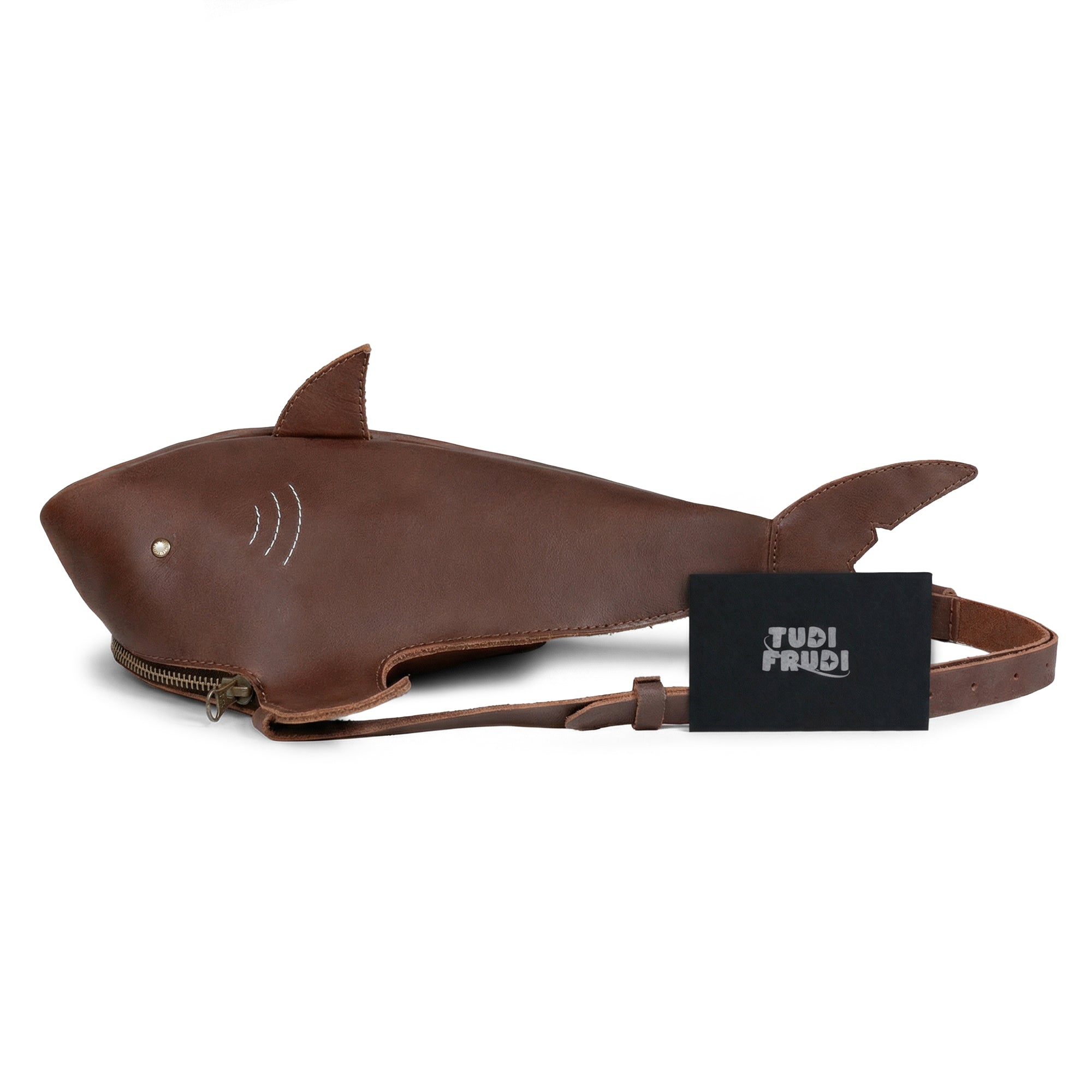Stylish Shark-Shaped Shoulder Bag from Tudi Frudi, complete with a branded tag, made from Full Grain Leather, featuring adjustable strap options, representing handmade quality from La Antigua Guatemala and Oaxaca Mexico, perfect for daily errands or travel.