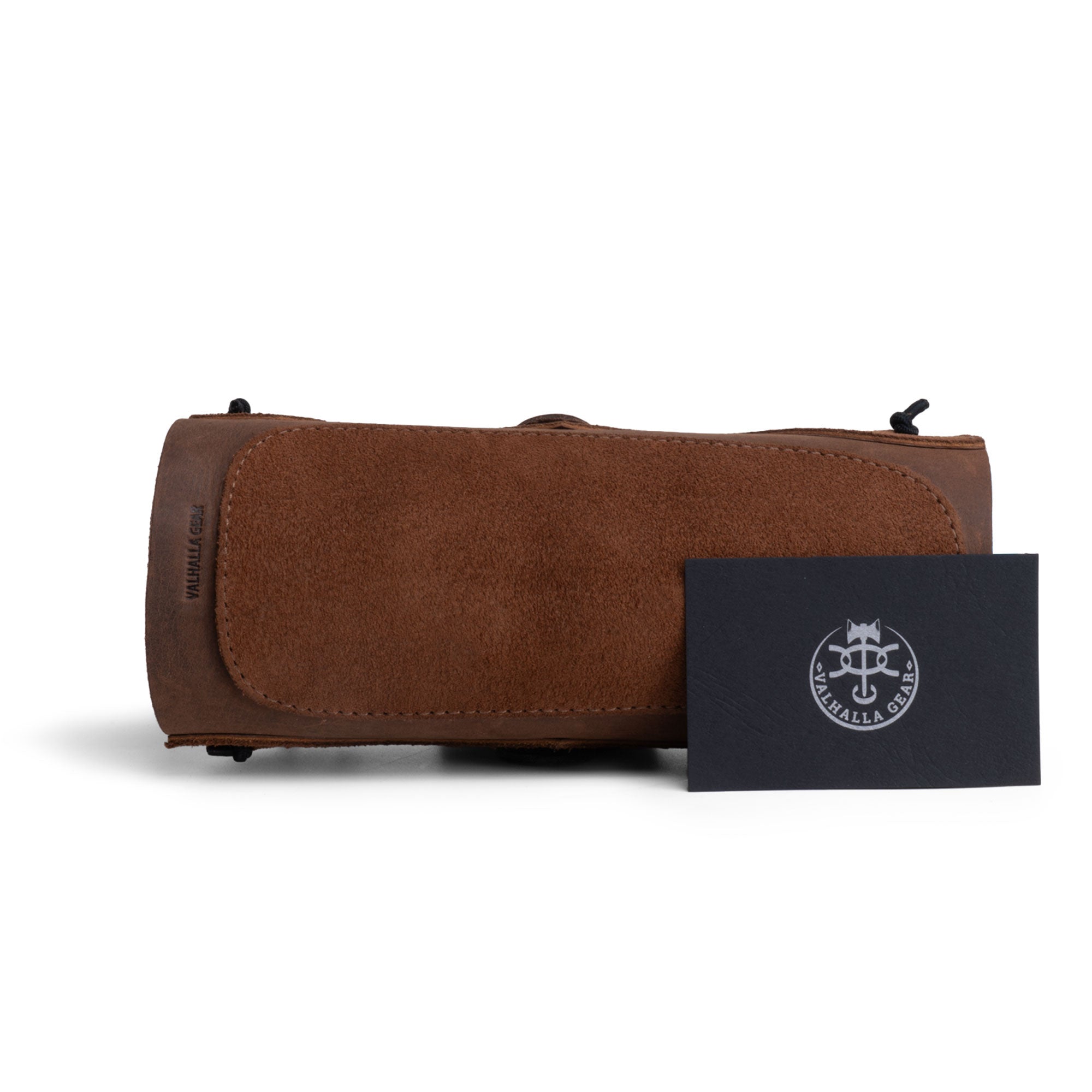 The Elastic Archery Bracer from Valhalla Gear on a flat surface next to an information card, emphasizing its full grain leather quality and artisan craftsmanship. This adjustable wrist guard is perfect for archers and cosplay lovers, embodying the spirit of small batch production from La Antigua Guatemala.