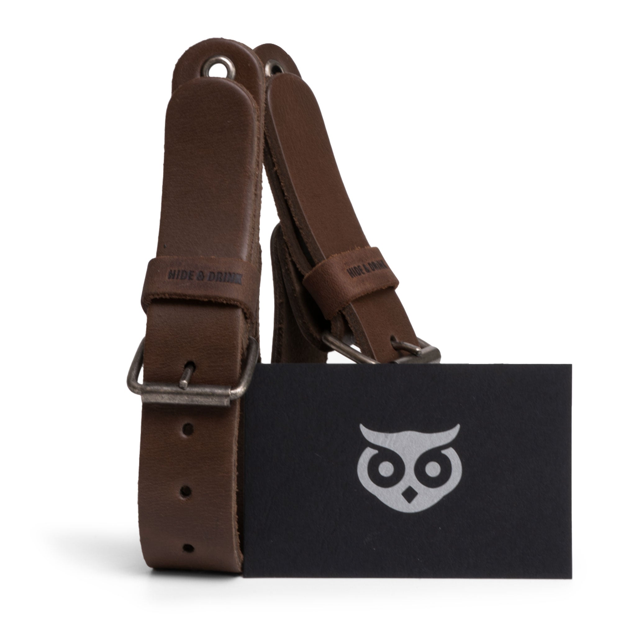 Image of Hide & Drink Wall Hanging Strap with its branding tag, exemplifying the artisan quality of this leather piece. Ideal as a gift or for personal organization, this wall hanging strap is made with full grain leather and highlights the features of a heavy-duty tool hanger. Each product is hand cut and sewn, showcasing small batch production in La Antigua Guatemala & Oaxaca Mexico.