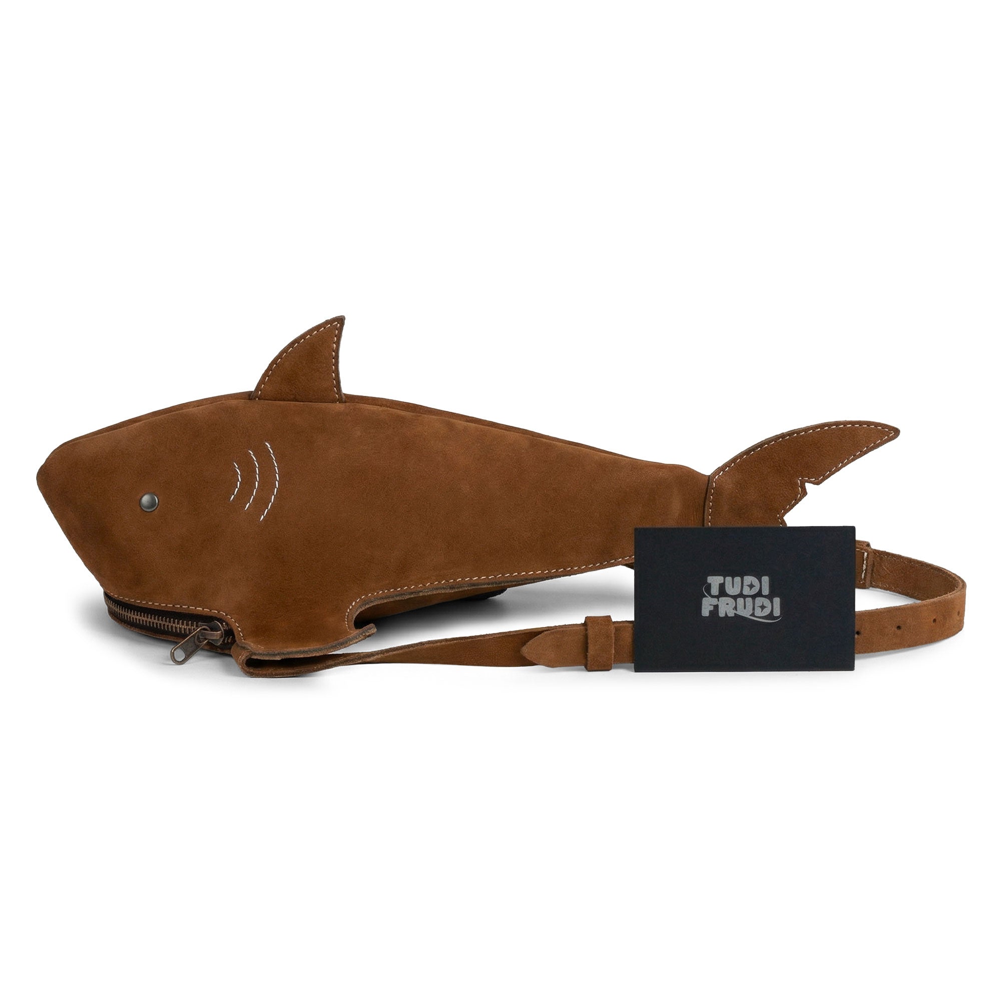Stylish display of the Shark-Shaped Shoulder Bag by Tudi Frudi, featuring its unique design and branding. Made from Full Grain Leather, this artisan-crafted bag offers an adjustable strap that allows it to be worn in multiple styles. Handmade in La Antigua Guatemala, its quality makes it a standout choice for lovers of small batch artisan goods.