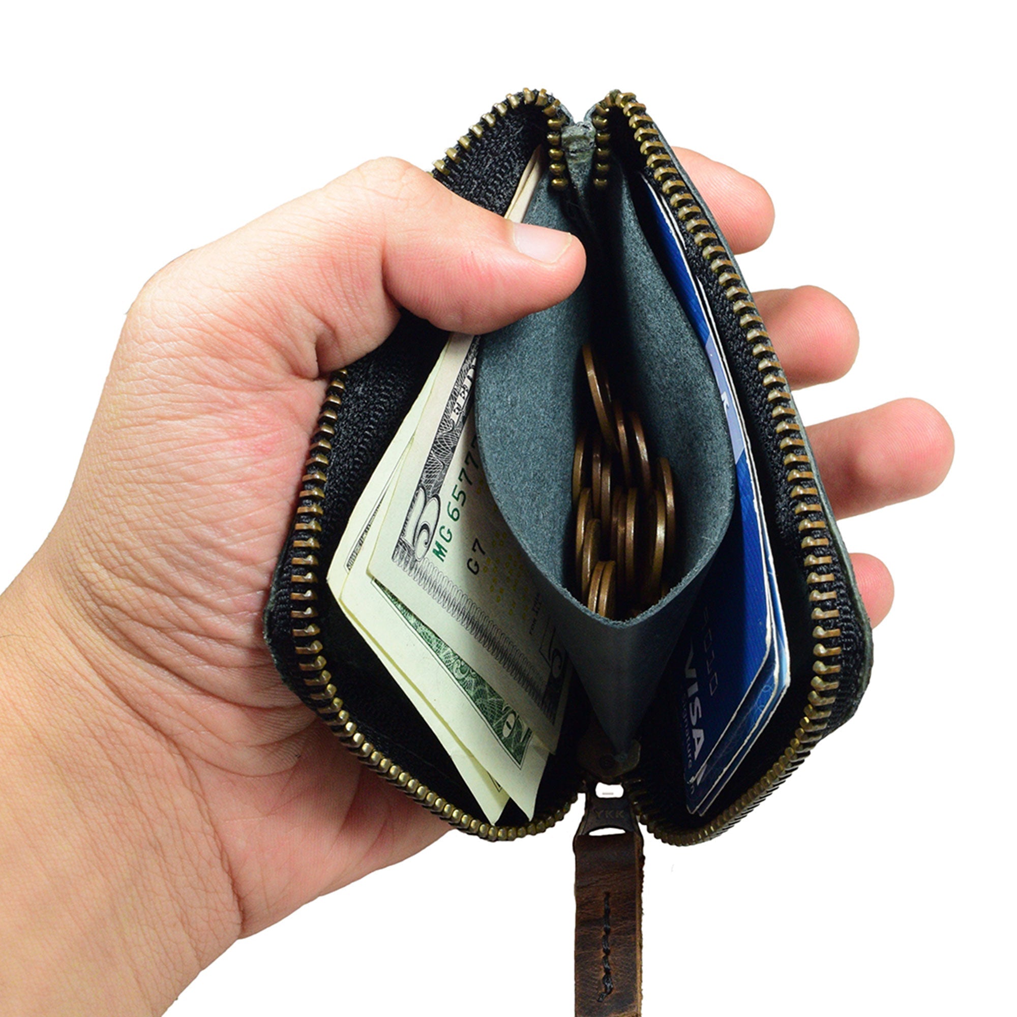 The tags attached to a black Hide & Drink Card Pocket Wallet showcasing its credentials. This zippered card wallet for men and women serves as a coin pouch and money holder, handmade from full grain leather, emphasizing the artisan’s craftsmanship in La Antigua Guatemala.