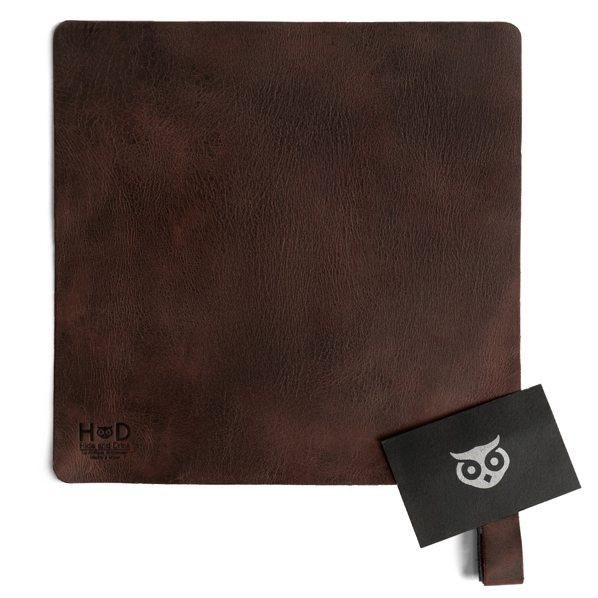 Hide & Drink's Potholder Sheet displayed with a branded card, emphasizing its quality and artisan craftsmanship. This full grain leather Squared Potholder Sheet is perfect for protection in the kitchen and adds a rustic touch to any culinary space. Handmade in La Antigua Guatemala & Oaxaca Mexico through small batch production.