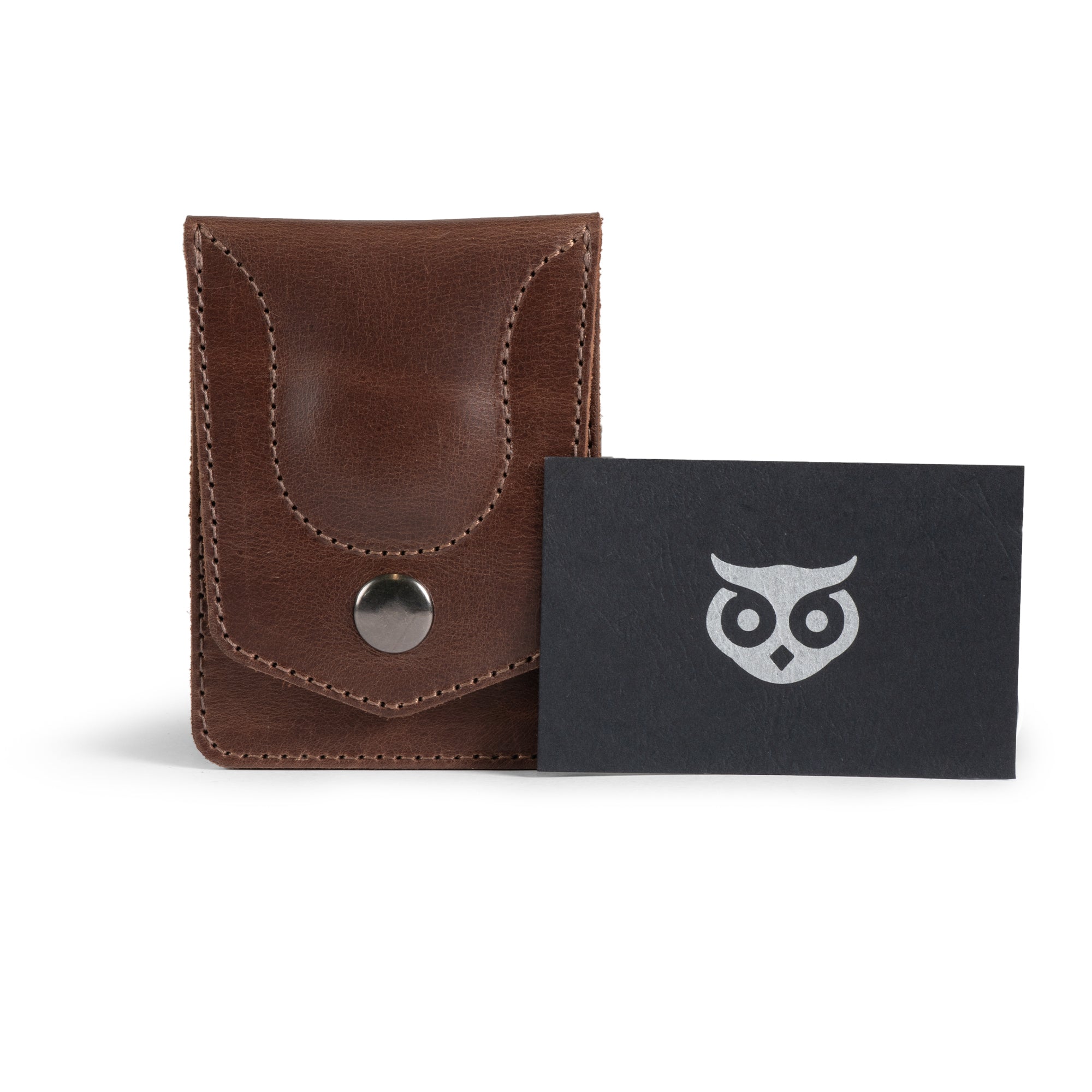 The Card Holder with AirTag Slot by Hide & Drink is elegantly displayed alongside a card, showcasing its vintage appeal. This handmade full grain leather wallet offers a GPS slot, serving as a multifunctional storage case for cash and cards.